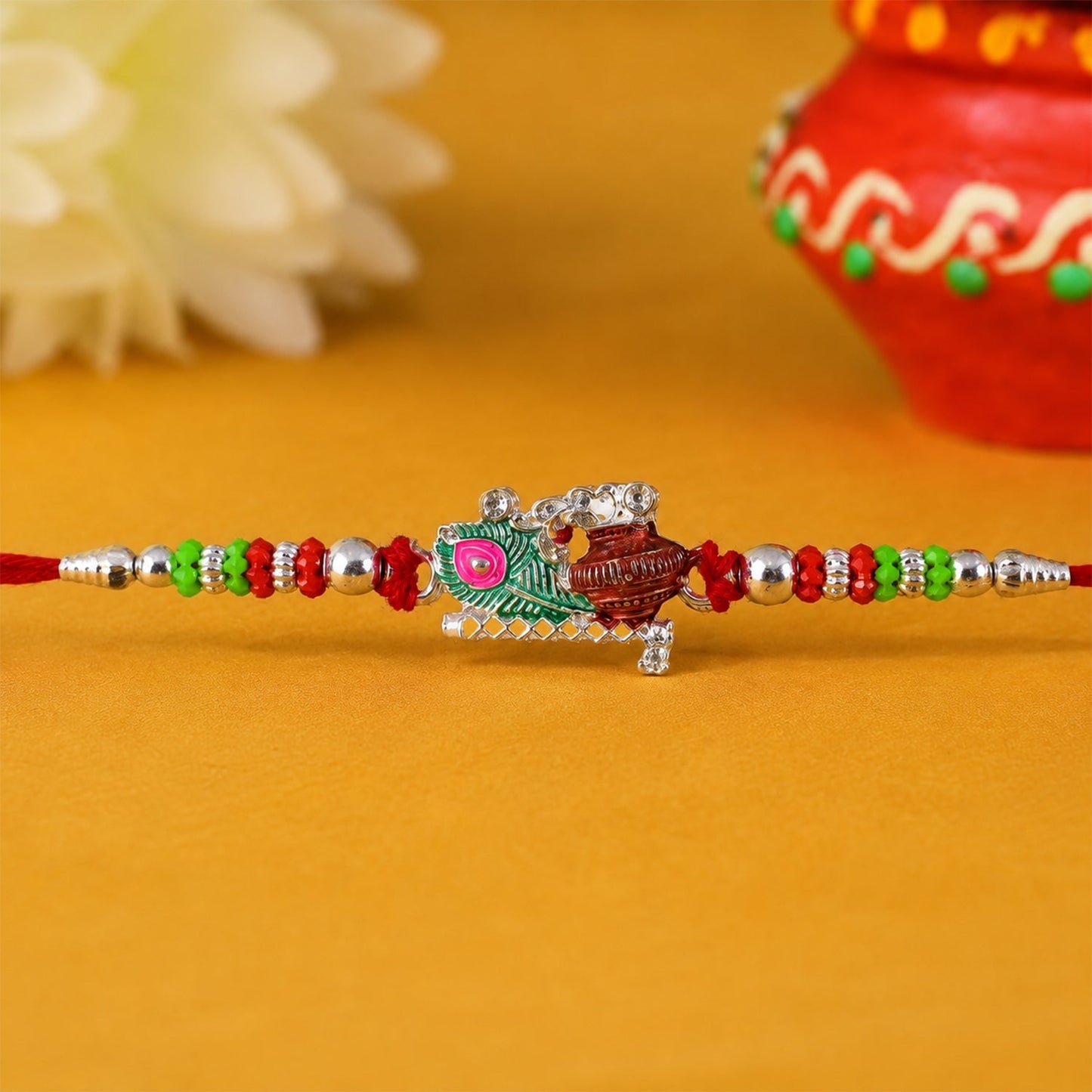 Intricate beadwork on Krishna Matki Rakhi with feather detail