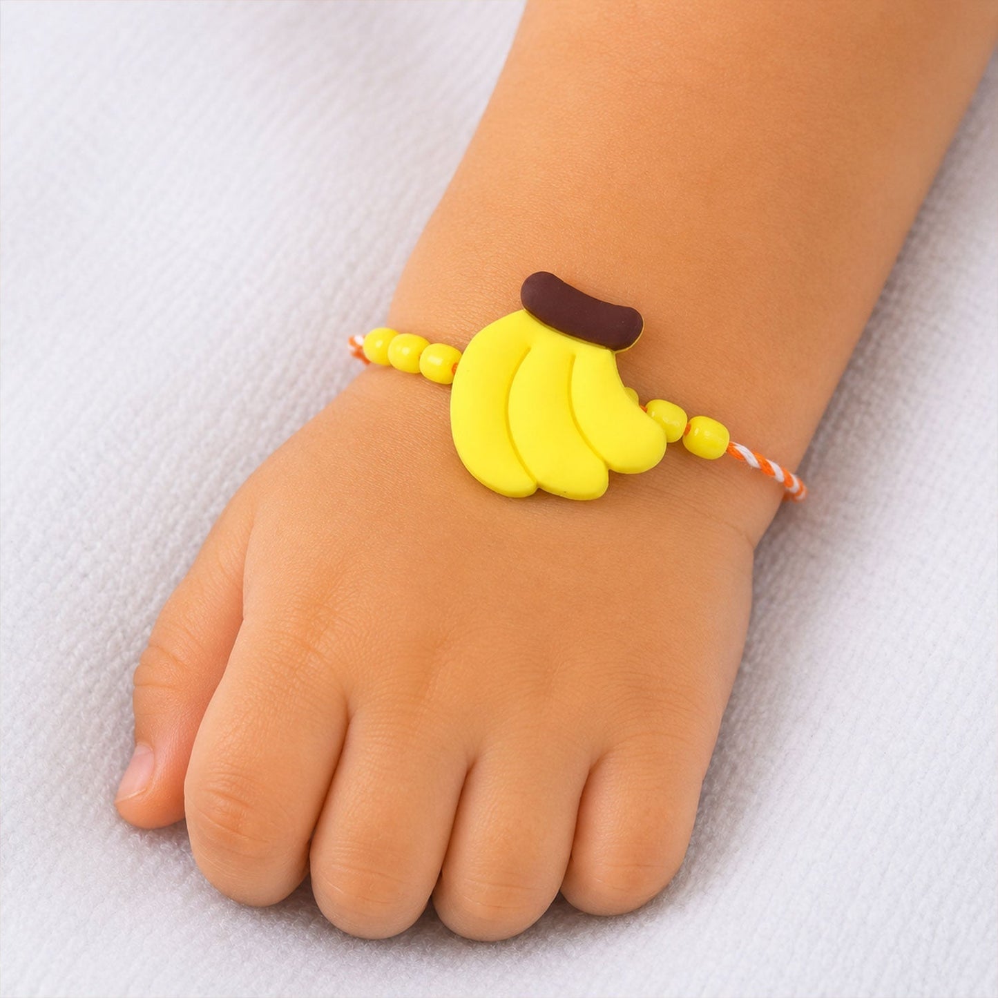 Close-up of playful banana charm on Rakhi