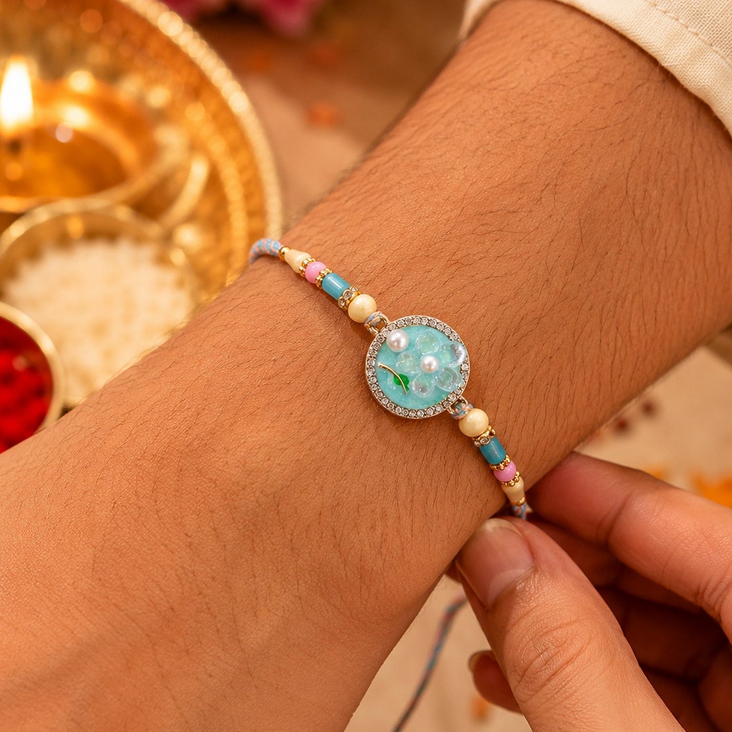 Close-up of teal floral pearl drops Rakhi showcasing detailed craftsmanship
