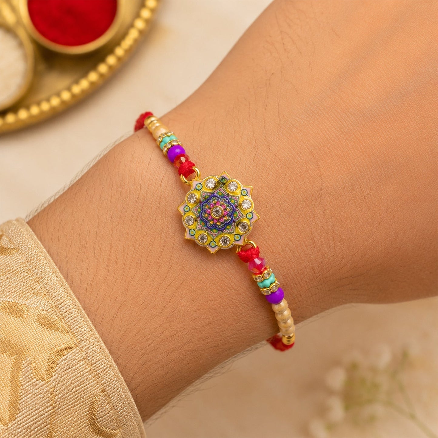 Angled shot showcasing the gold tone and detailed design of the Rakhi.
