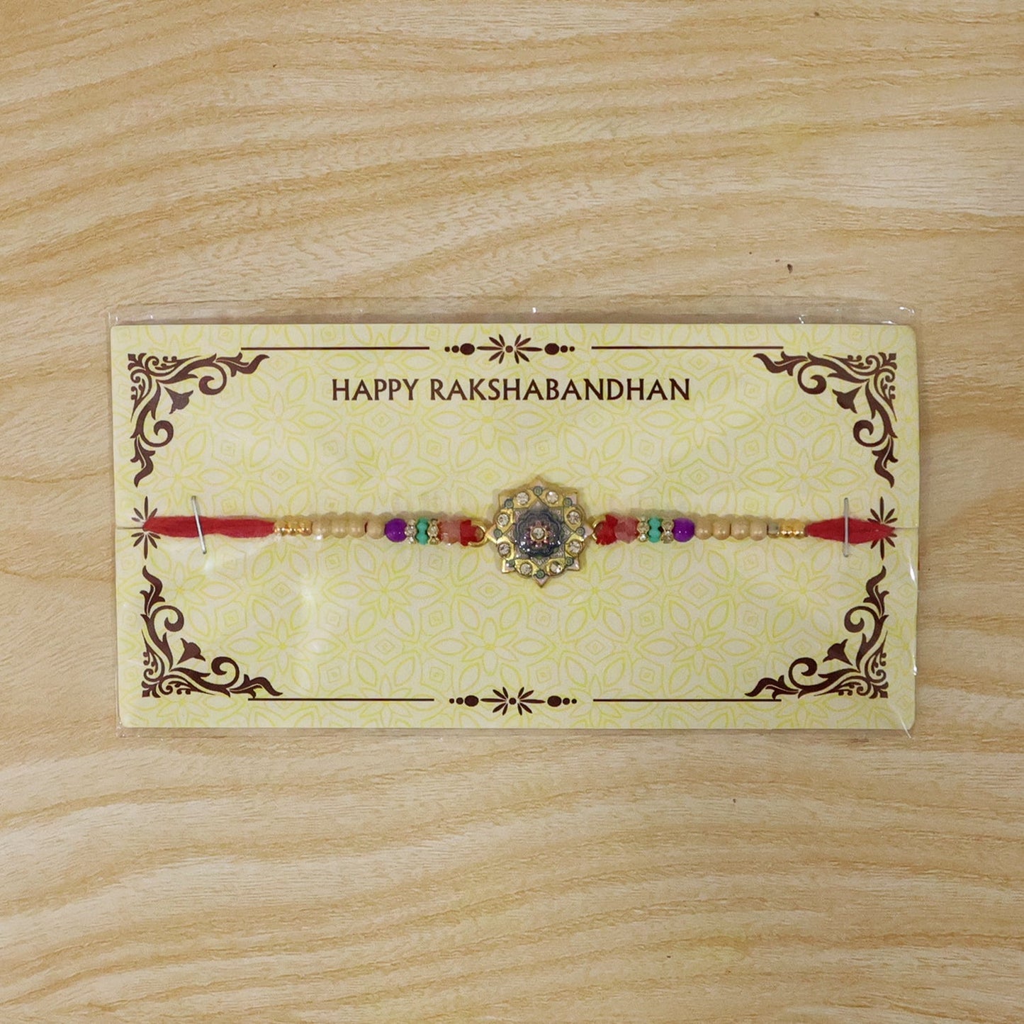 Display of the complete gold tone Rakhi with vibrant thread.