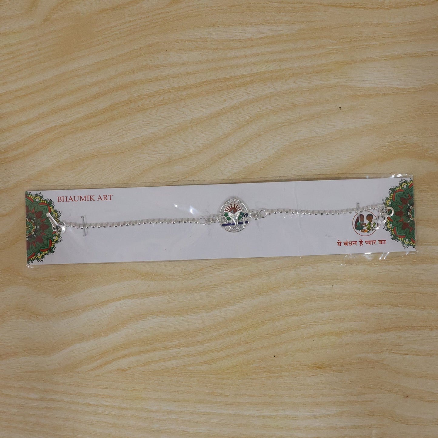 Beautifully crafted Lord Ganesha rakhi with enamel detailing on a traditional festive background
