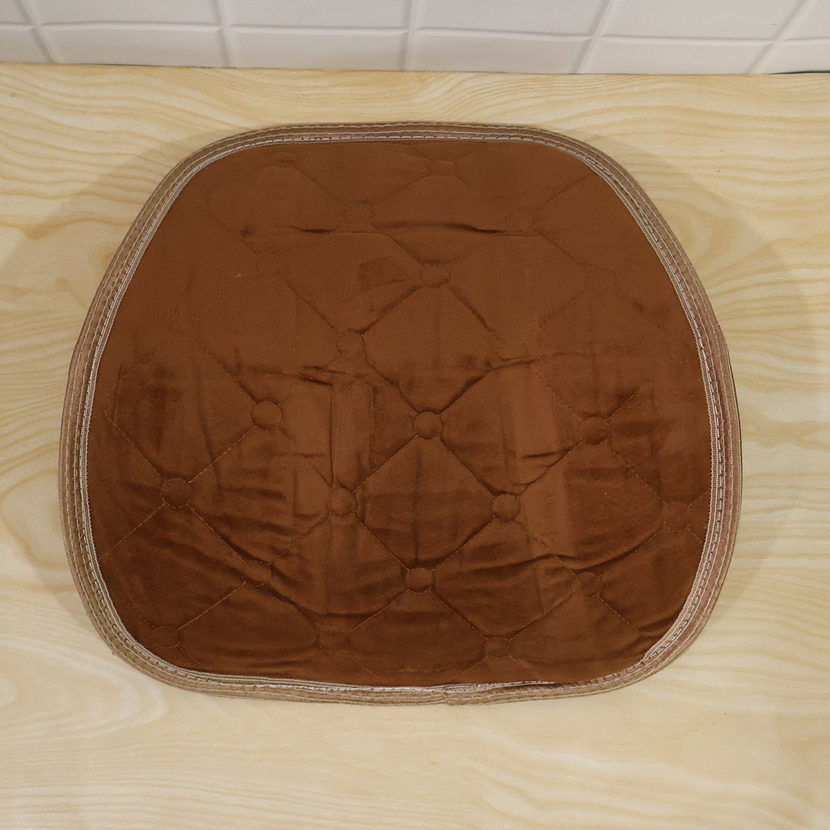 Brown quilted velvet lumbar support cushion with clear strap mechanism