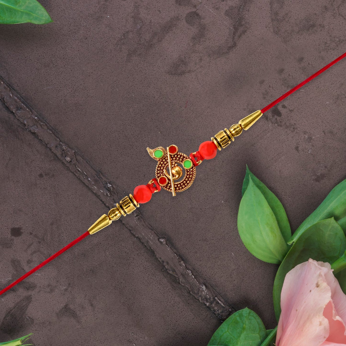 Elegant Krishna Rakhi displaying intricate Krishna symbol and red beads on festive background.