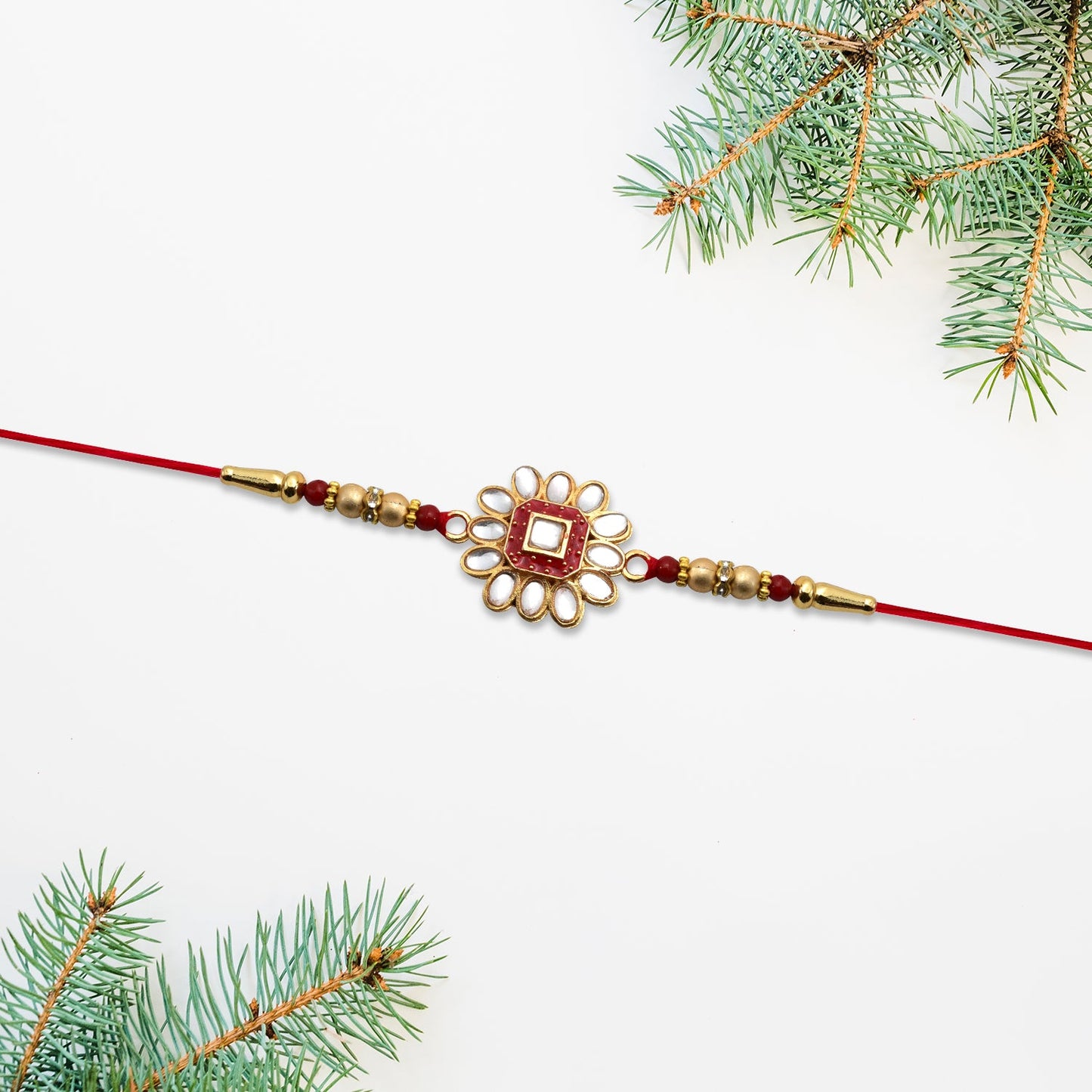 Traditional Rakhi with prominent flower design set against Rakshabandhan festive backdrop.