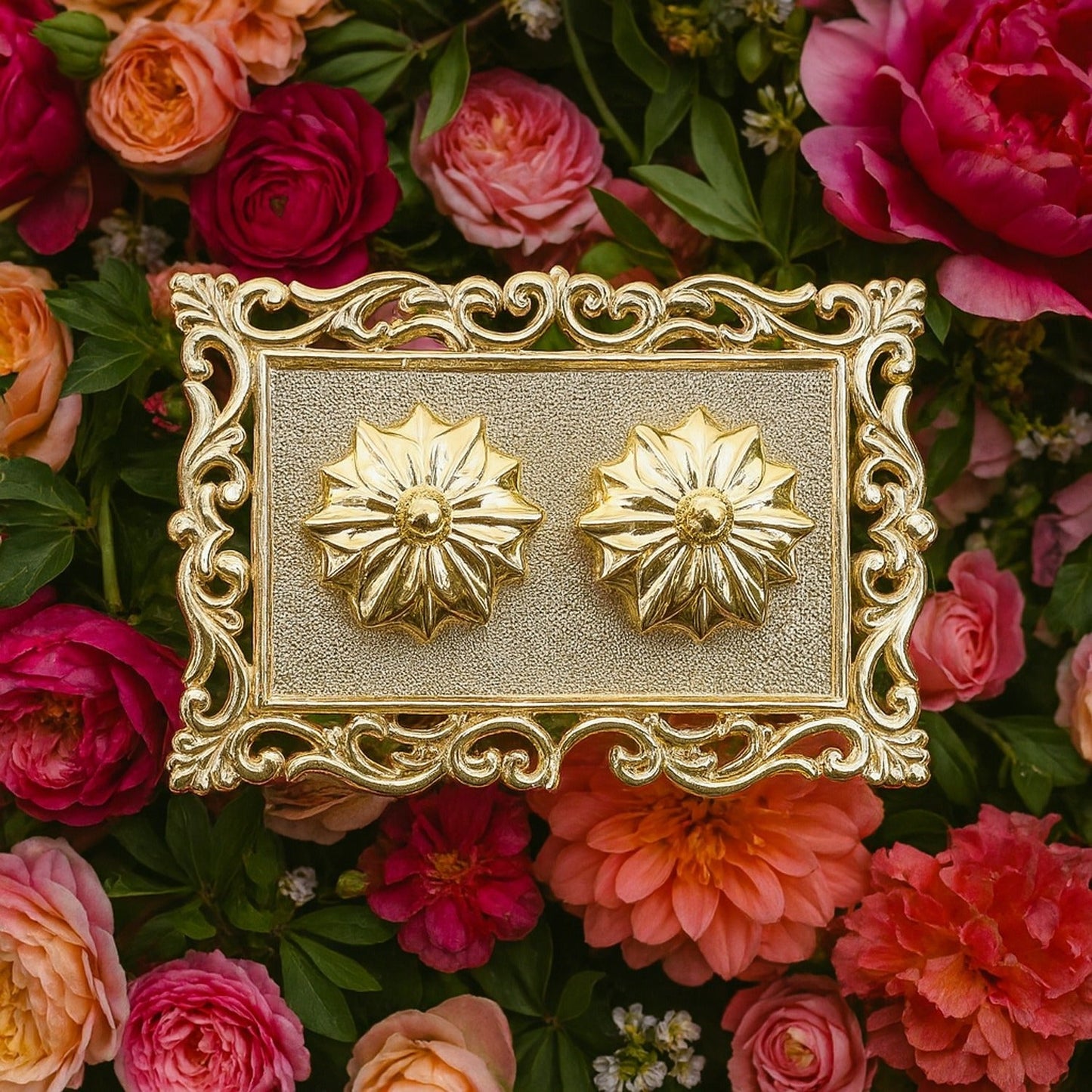 A gold rectangular pooja thali with two flower-shaped containers, surrounded by red and orange flowers.