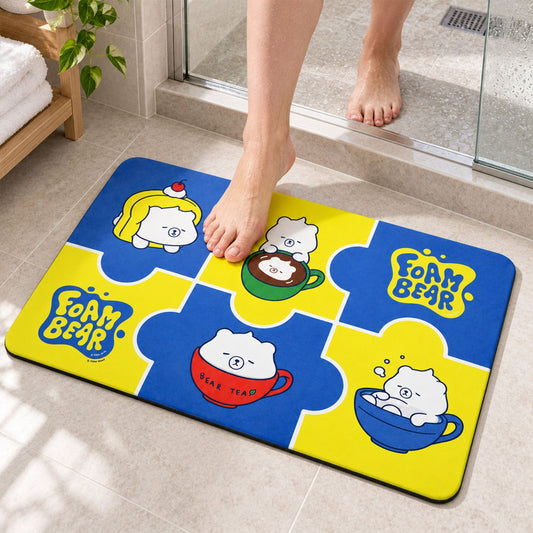 A person's bare feet step onto a blue and yellow foam bath mat with cartoon bears in cups.
