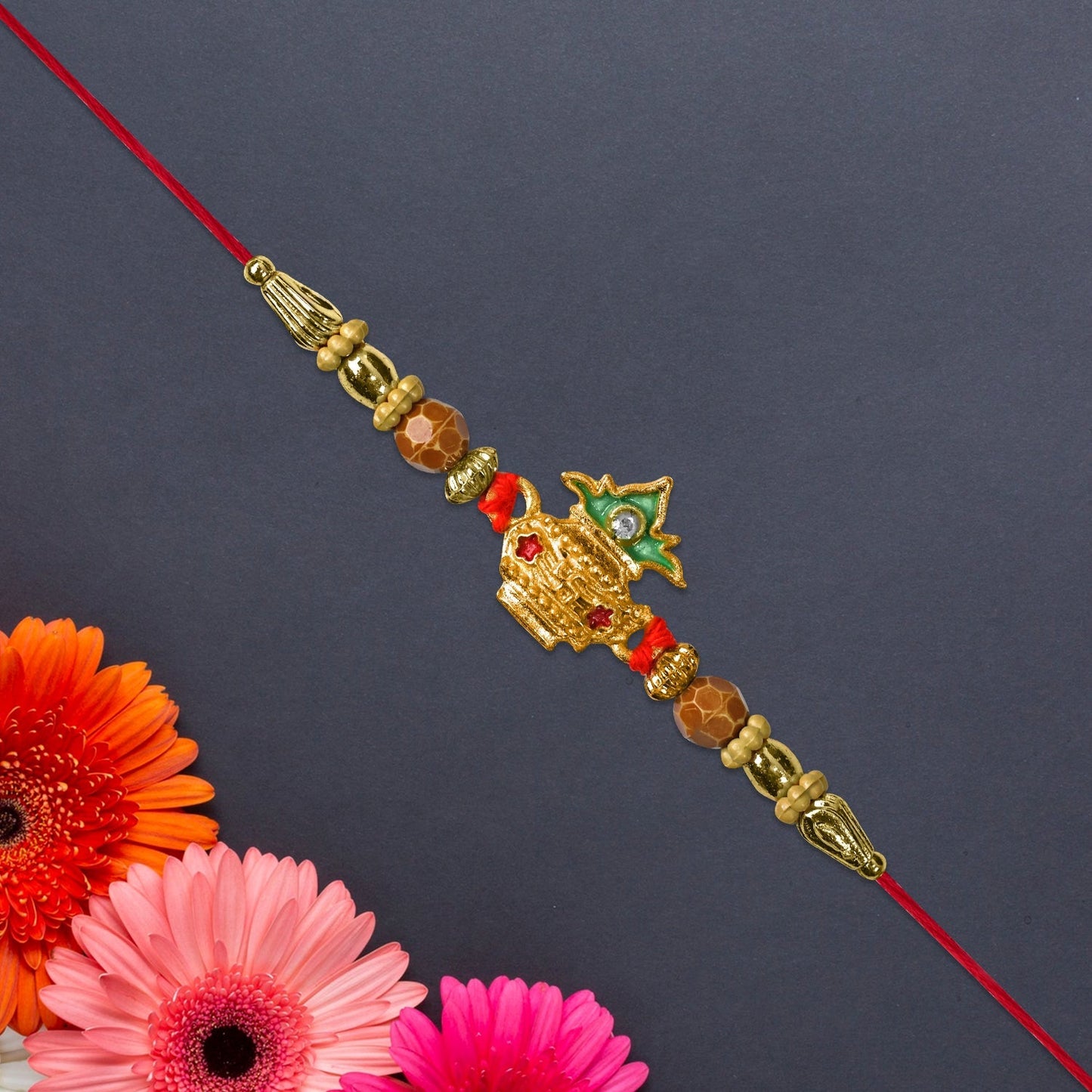 Close-up of golden Kalash motif on Rakhi adorned with detailed pearl beadwork highlighting craftsmanship.