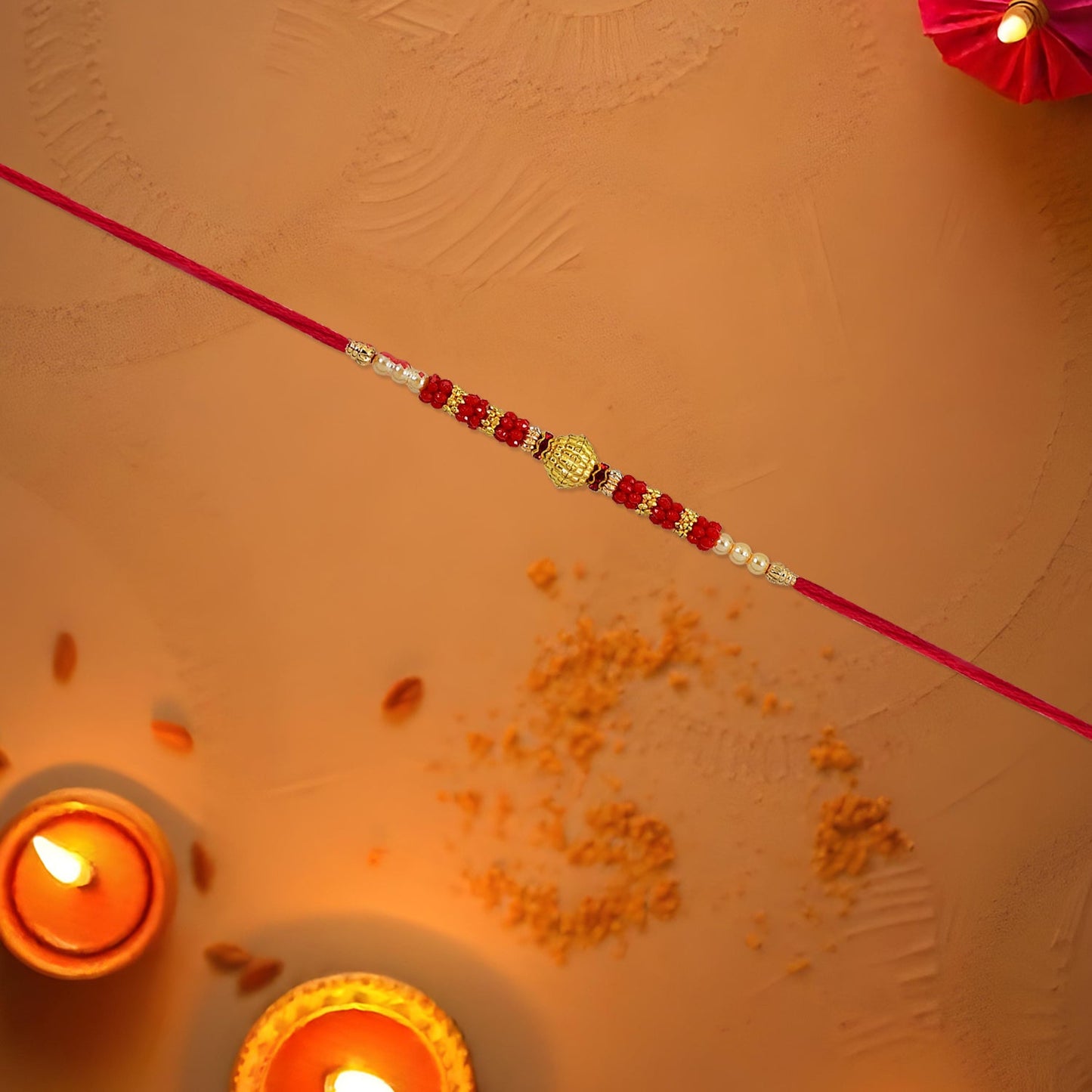 Close-up of the golden textured centerpiece on the Red Bead Rakhi