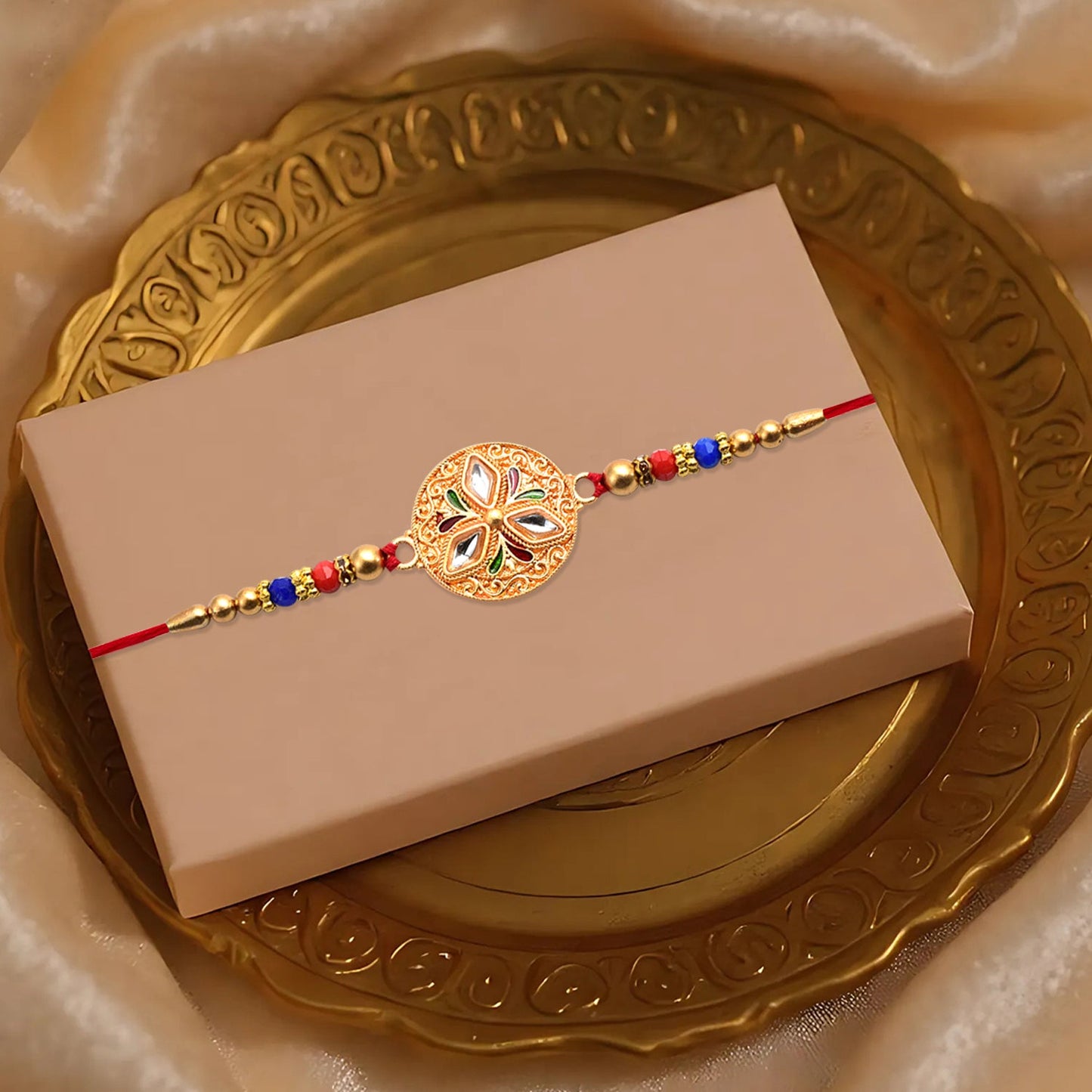 Close-up of colorful beads and gold detailing on handcrafted Meenakari floral Rakhi