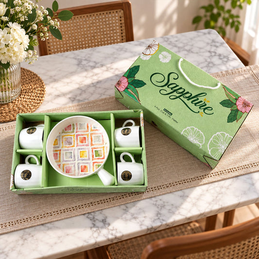 A five-piece ceramic set, including four white mugs and a platter with a colorful square pattern, in a green gift box.