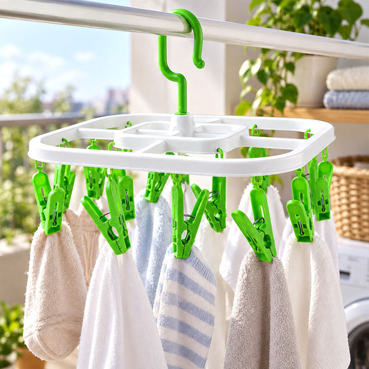 White square drying rack with green clips holding small towels on a balcony clothesline.