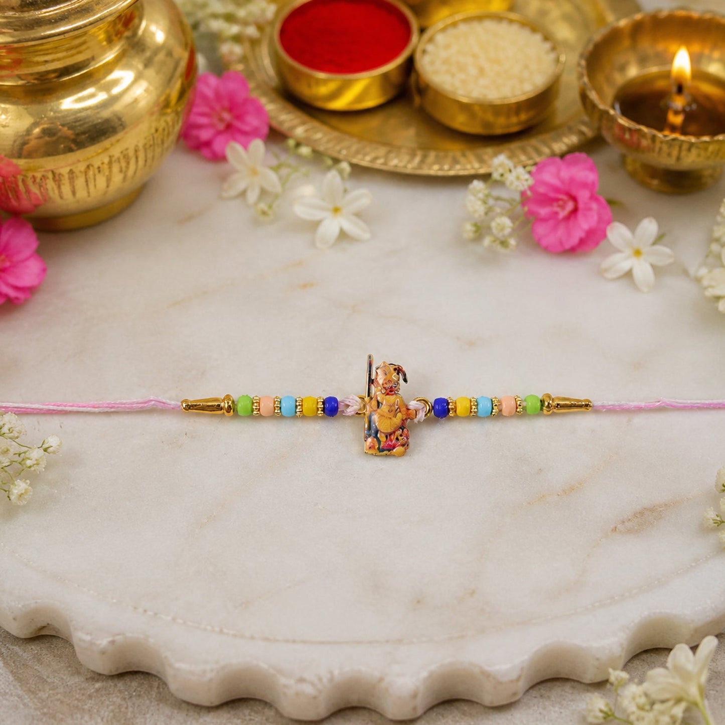 Hand holding vibrant Hanuman Ji Rakhi with beads and soft thread