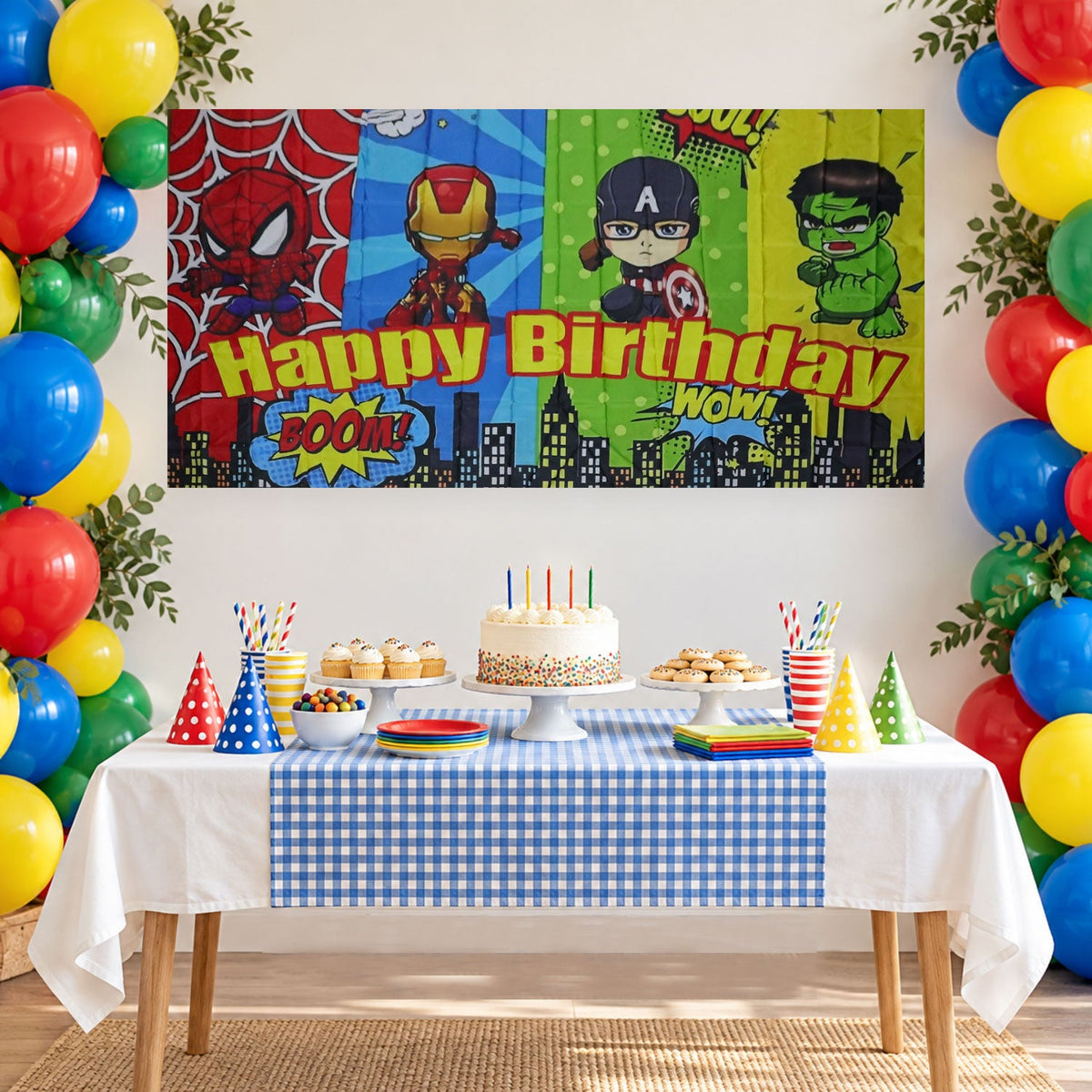Happy Birthday superhero backdrop behind a blue checkered cake table and balloons