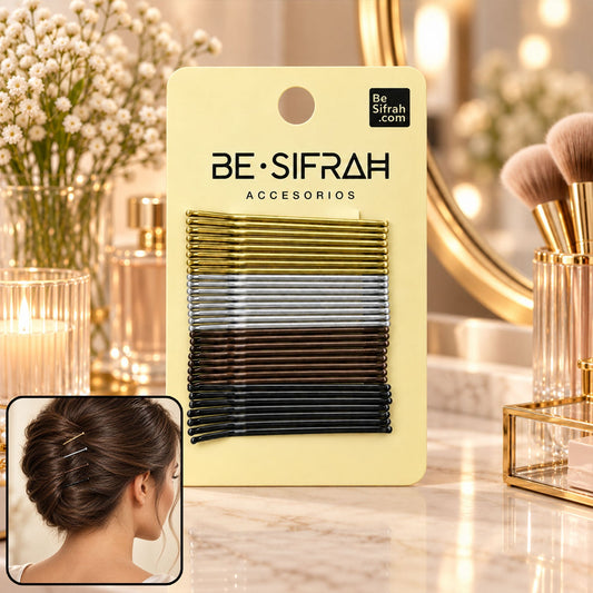 A yellow card holds gold, silver, brown, and black bobby pins, with a woman's styled hair bun in the corner.