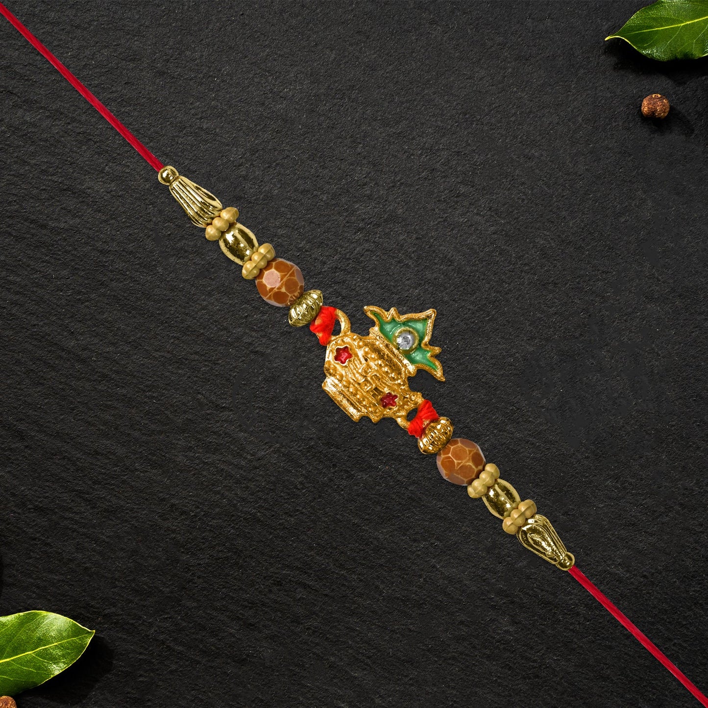 Traditional Golden Kalash Rakhi featuring golden finish with shiny Moti pearl accents.