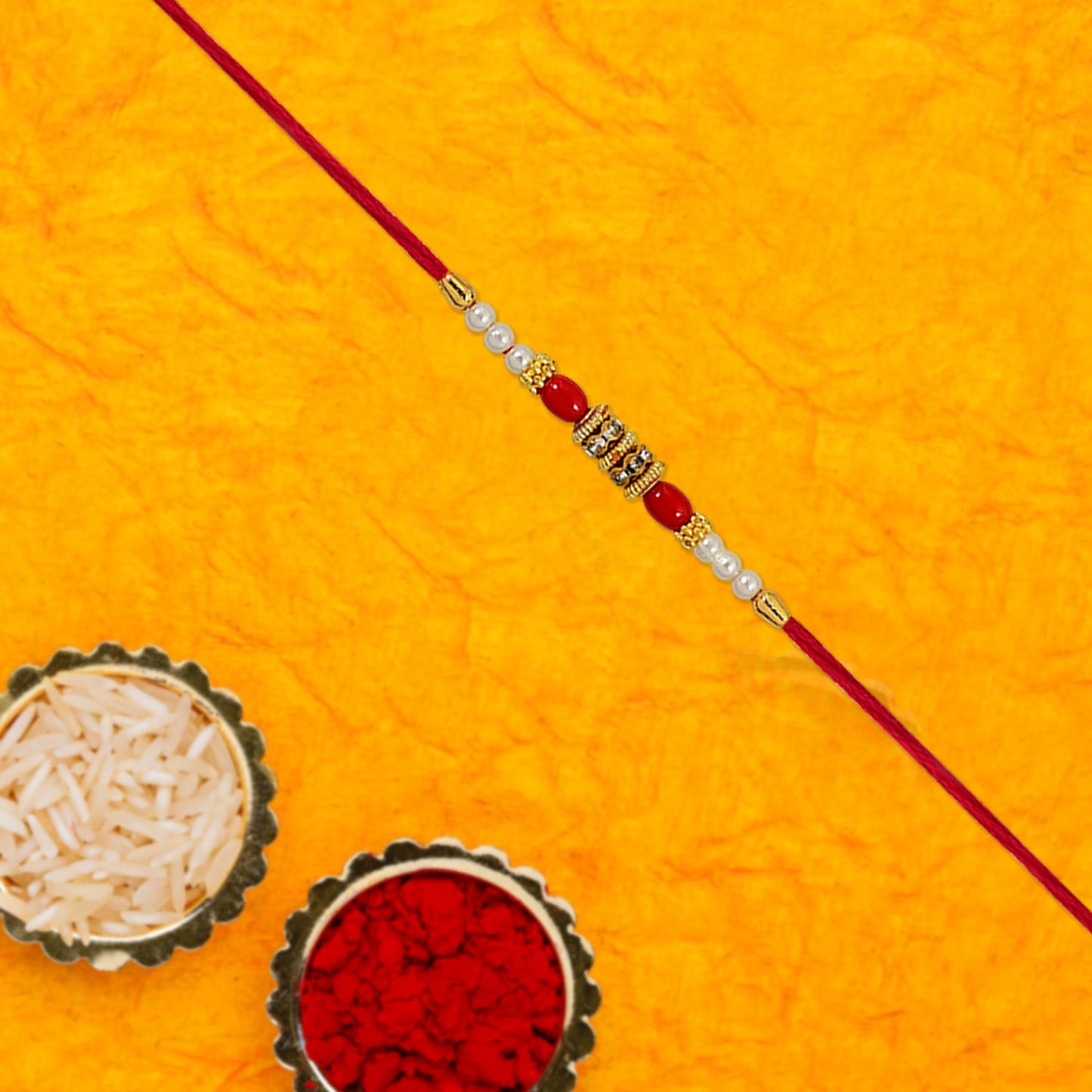 Close-up of Pearl Beaded Rakhi showing lustrous pearls and bright red beads on soft thread.