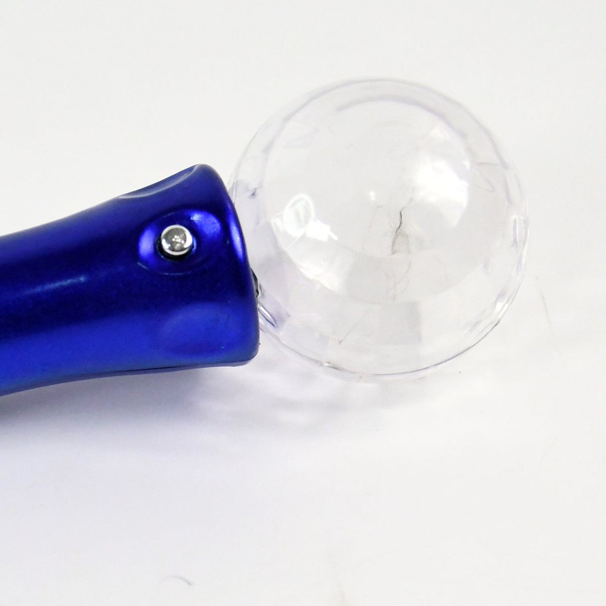 Close-up of the blue handle and clear disco ball top of the light wand on a white surface.