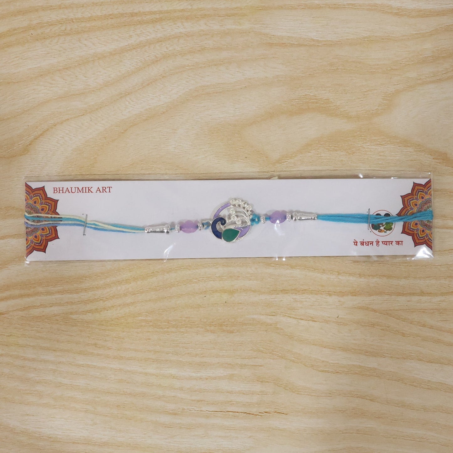 Close-up of intricate Peacock motif Rakhi with beads and thread