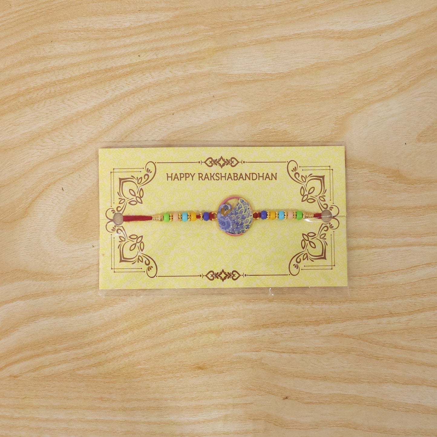 Full view of the Peacock Rakhi with vibrant multicolor beads.