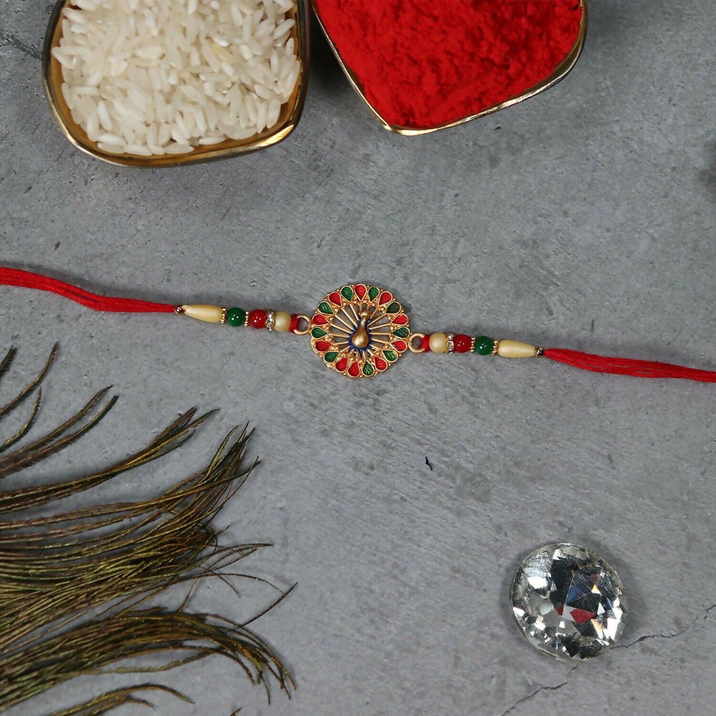 Side view of Vinayak Vrat Rakhi resting on soft fabric, emphasizing its design.