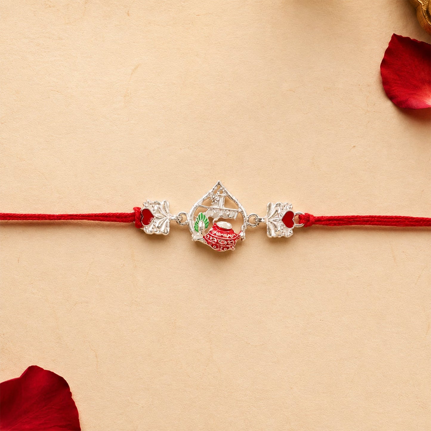 Silver Crown Rakhi styled with red mauli thread and decorative elements