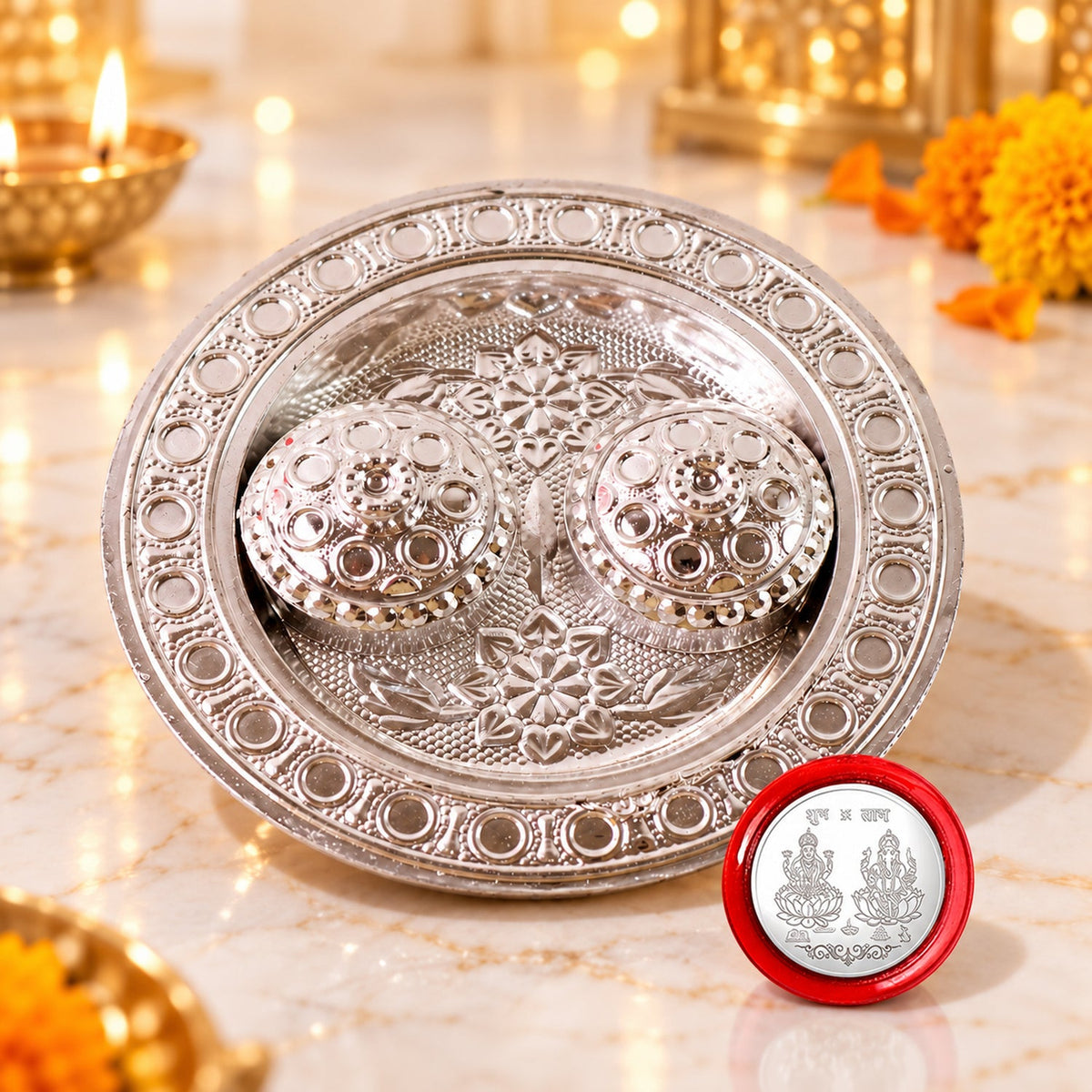 A close-up of a silver kumkum dish with two mirror-embellished containers and a red coin featuring deities.