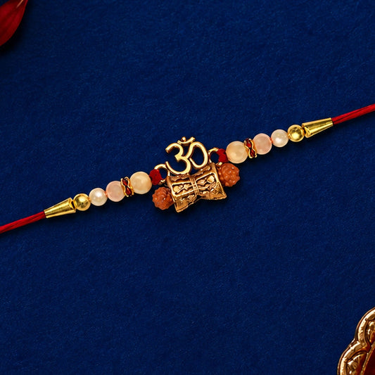 Golden Charm Rakhi with pearl beads and red thread, perfect for Raksha Bandhan celebrations.