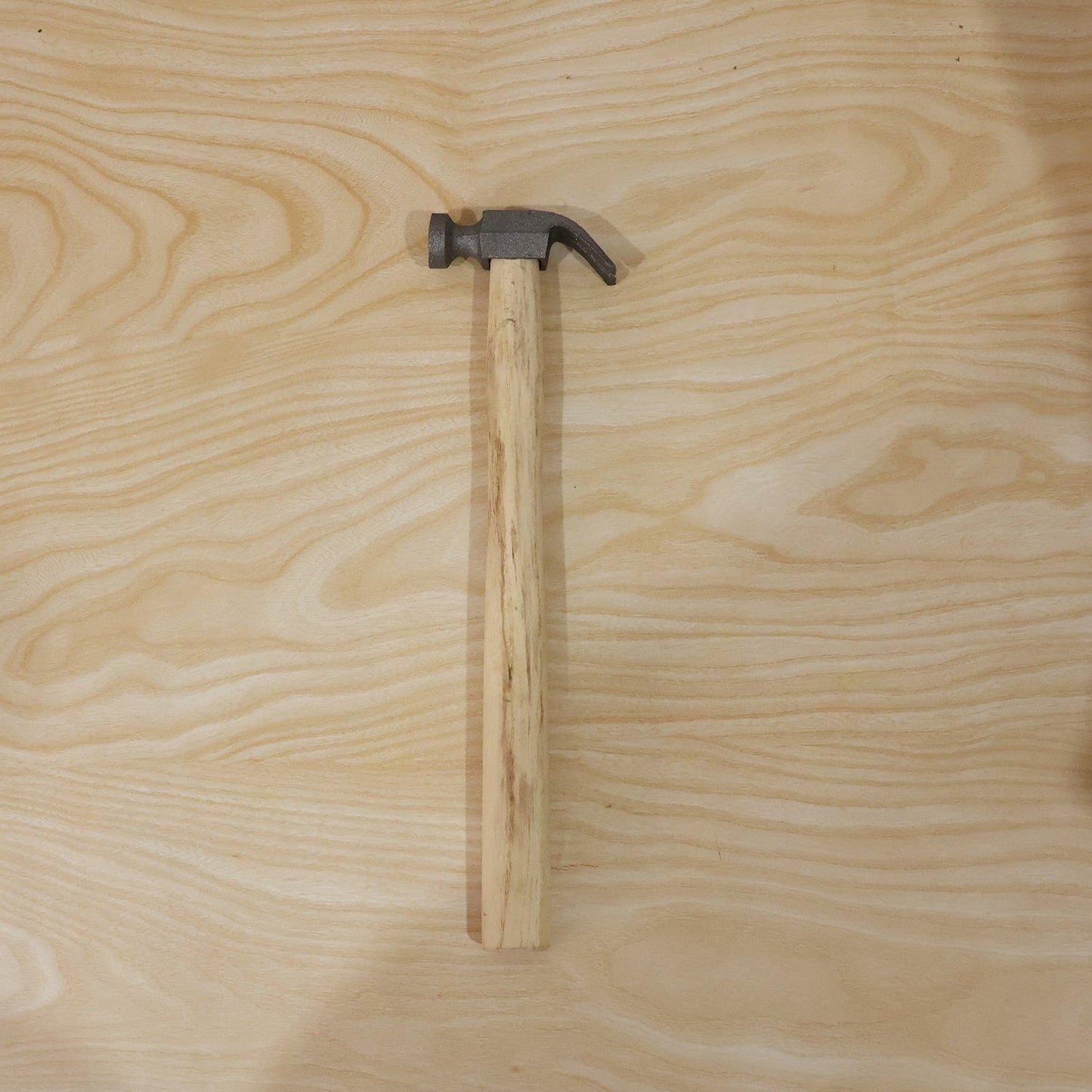 Person using claw hammer to drive a nail
