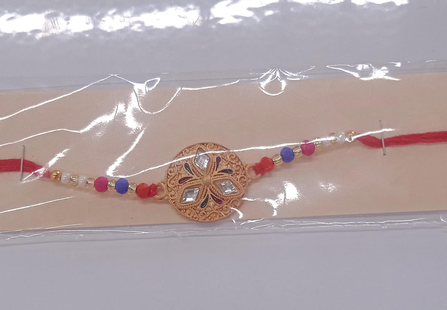 Stylish full view of Meenakari floral Rakhi with golden accents and colorful beads
