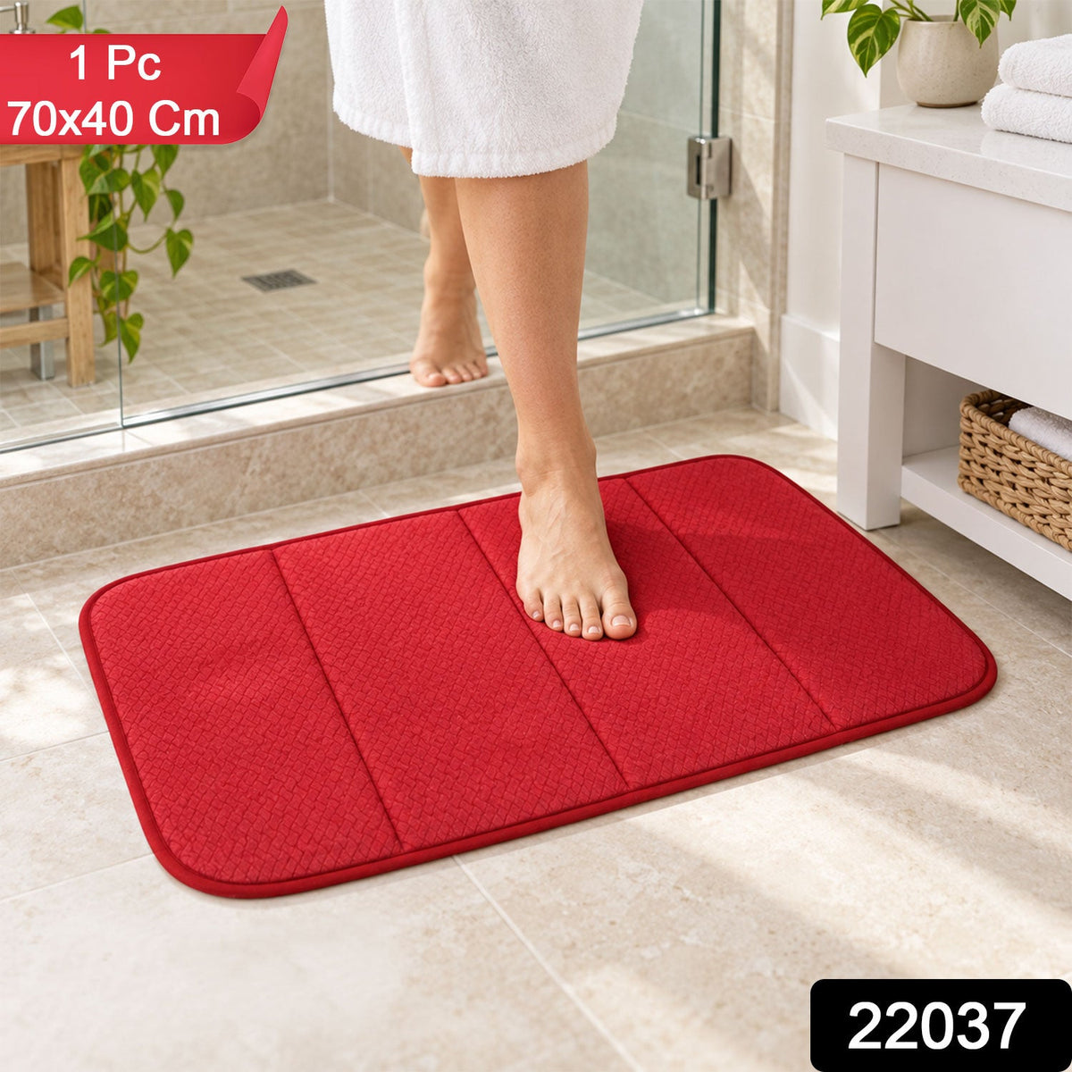 A person's bare feet step onto a red rectangular bath mat with a textured surface, on a light tiled bathroom floor.