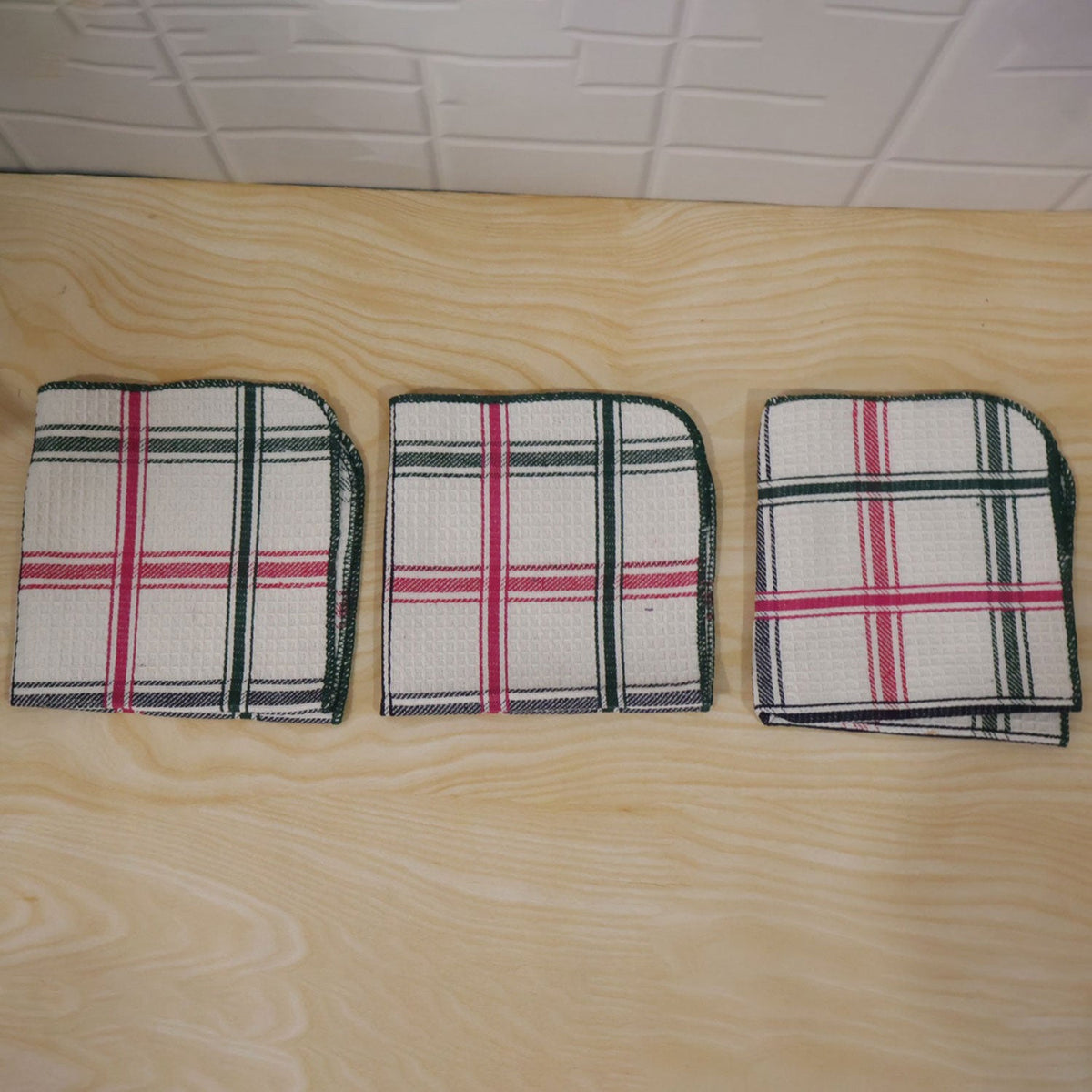 Actual photograph of three folded checked dish cloths
