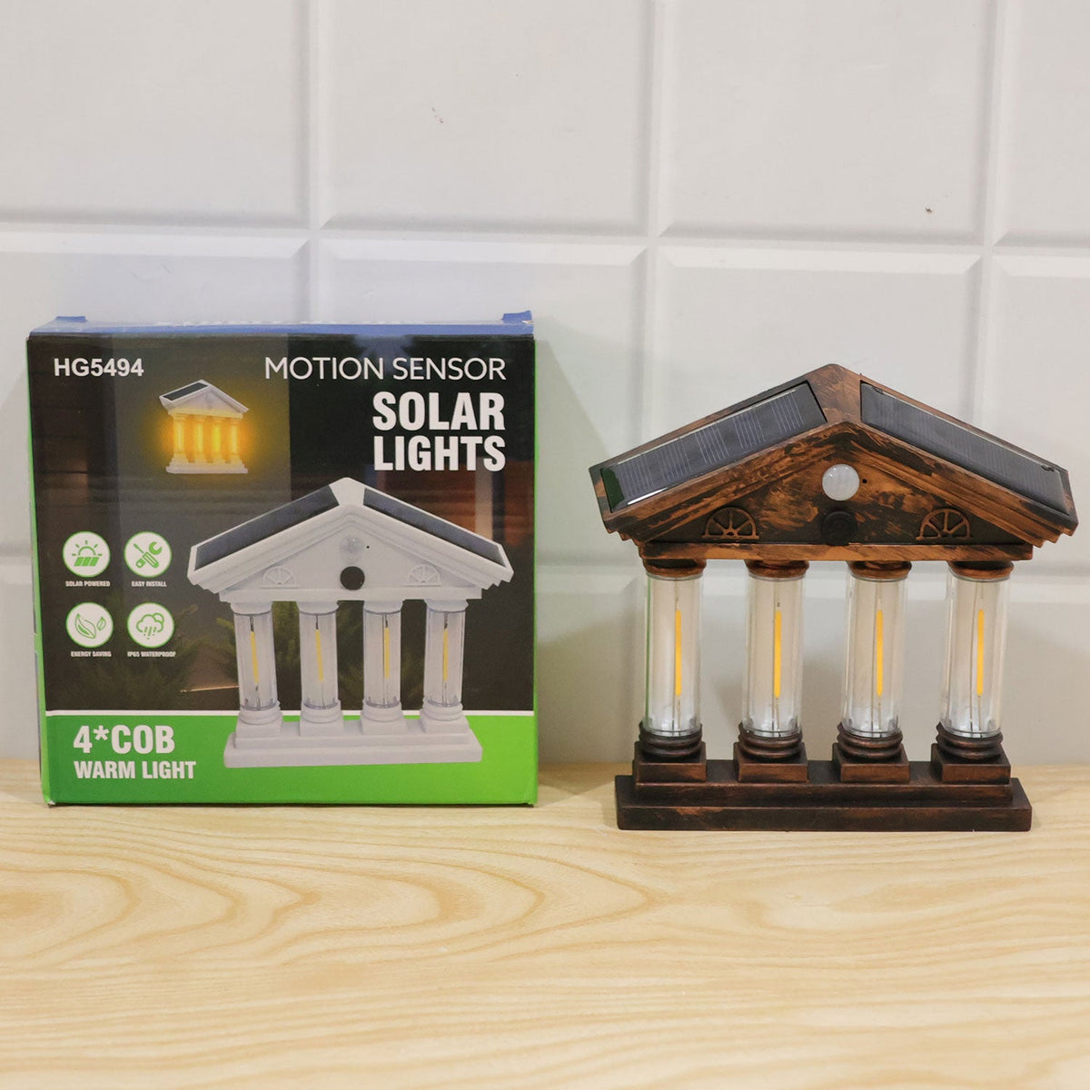 The solar wall light displayed next to its green and blue product box, which features an illustration of the light and text