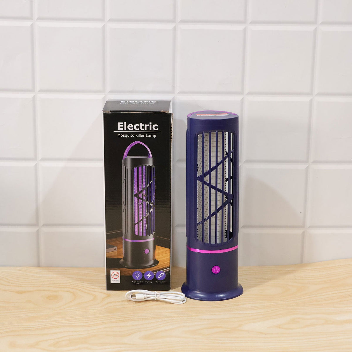 The mosquito lamp, its box, and a white USB cable sit on a light wooden surface against a tiled wall.
