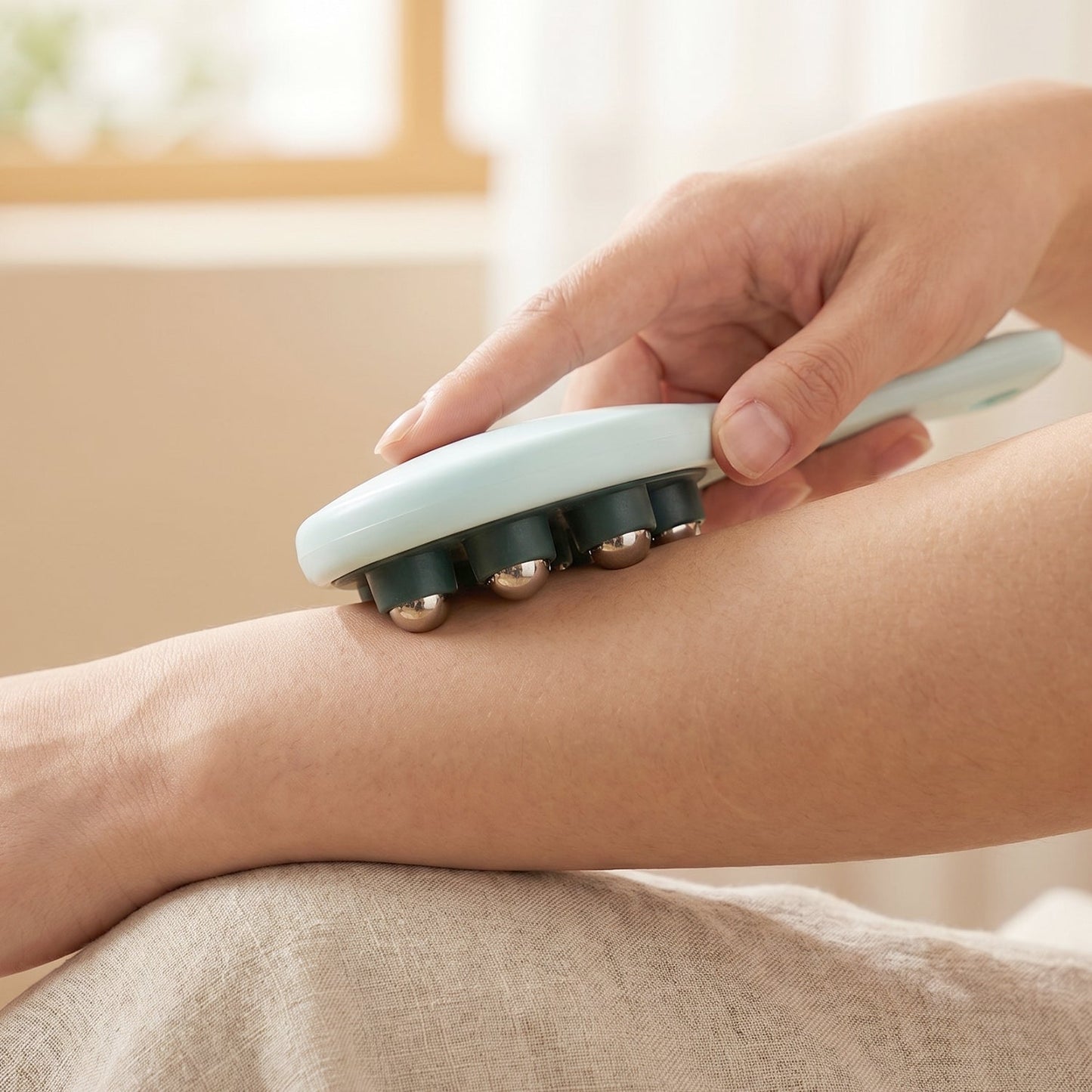 User applying the steel ball massager to a shoulder for muscle relaxation.