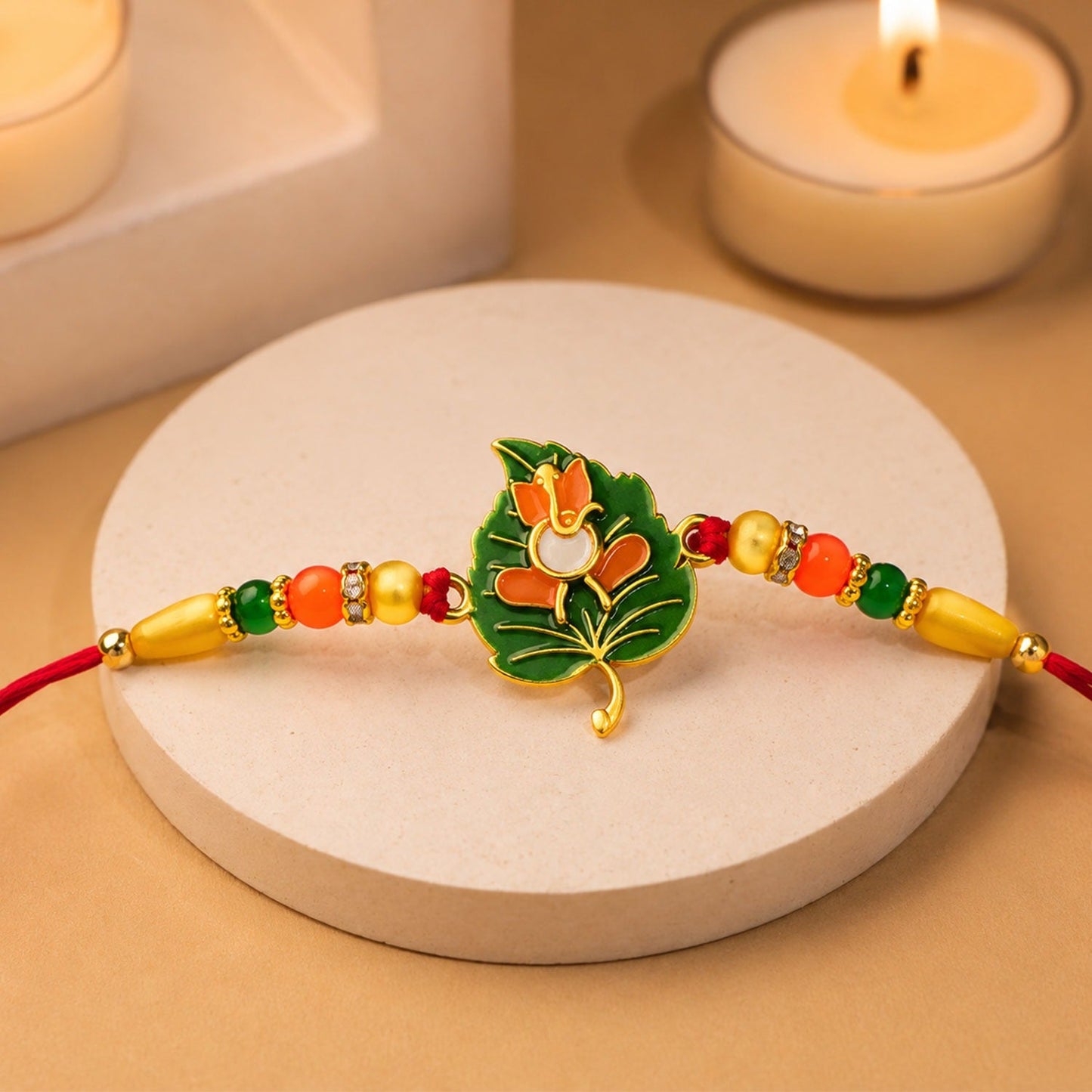 Close-up of a vibrant Tulsi Leaf Rakhi with an orange enamel flower and colourful beaded thread.