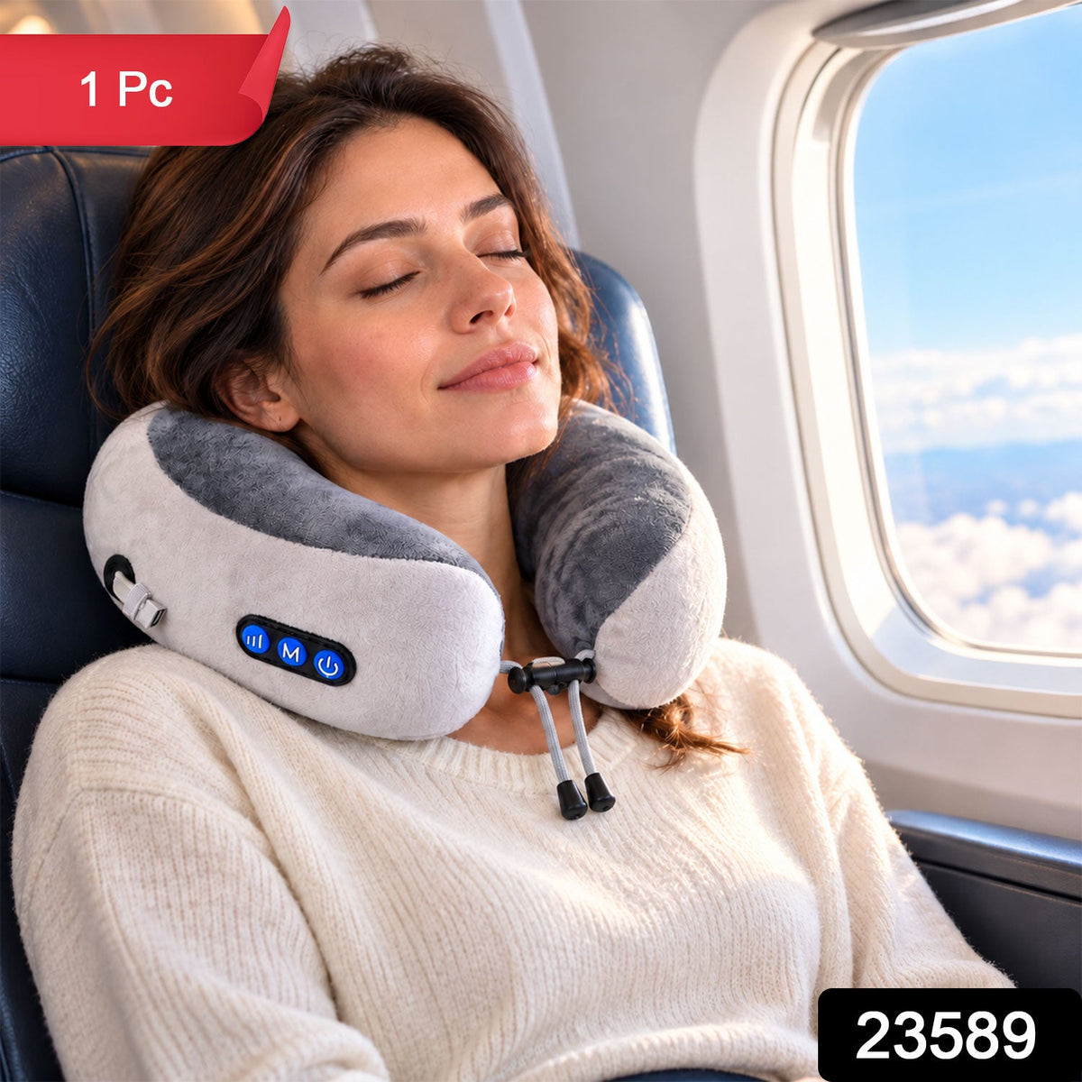 A woman with closed eyes relaxes on an airplane seat, wearing a grey and white U-shaped neck massage pillow. â€“ view 2