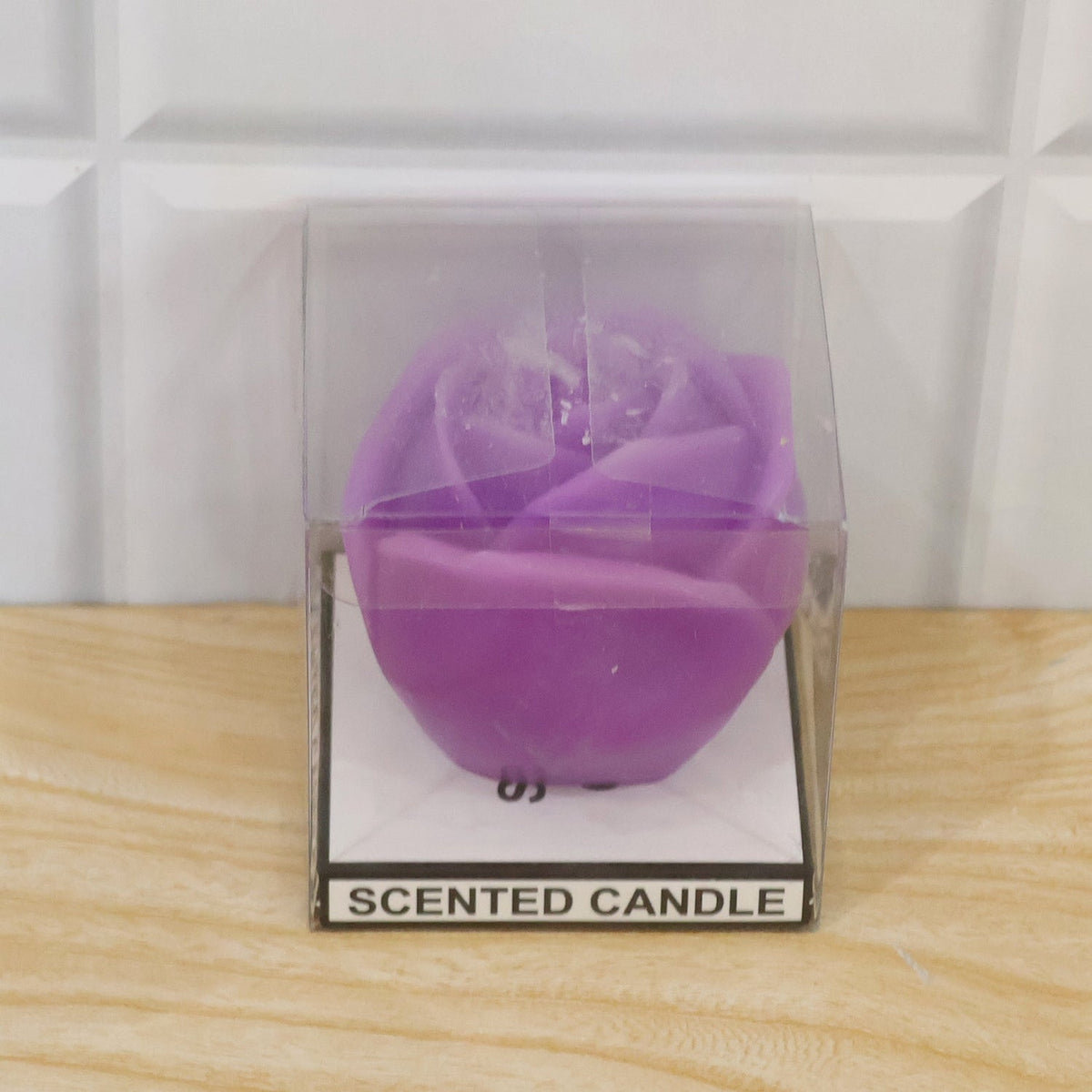 A purple rose-shaped candle is packaged in a clear plastic box with a label that says "SCENTED CANDLE".