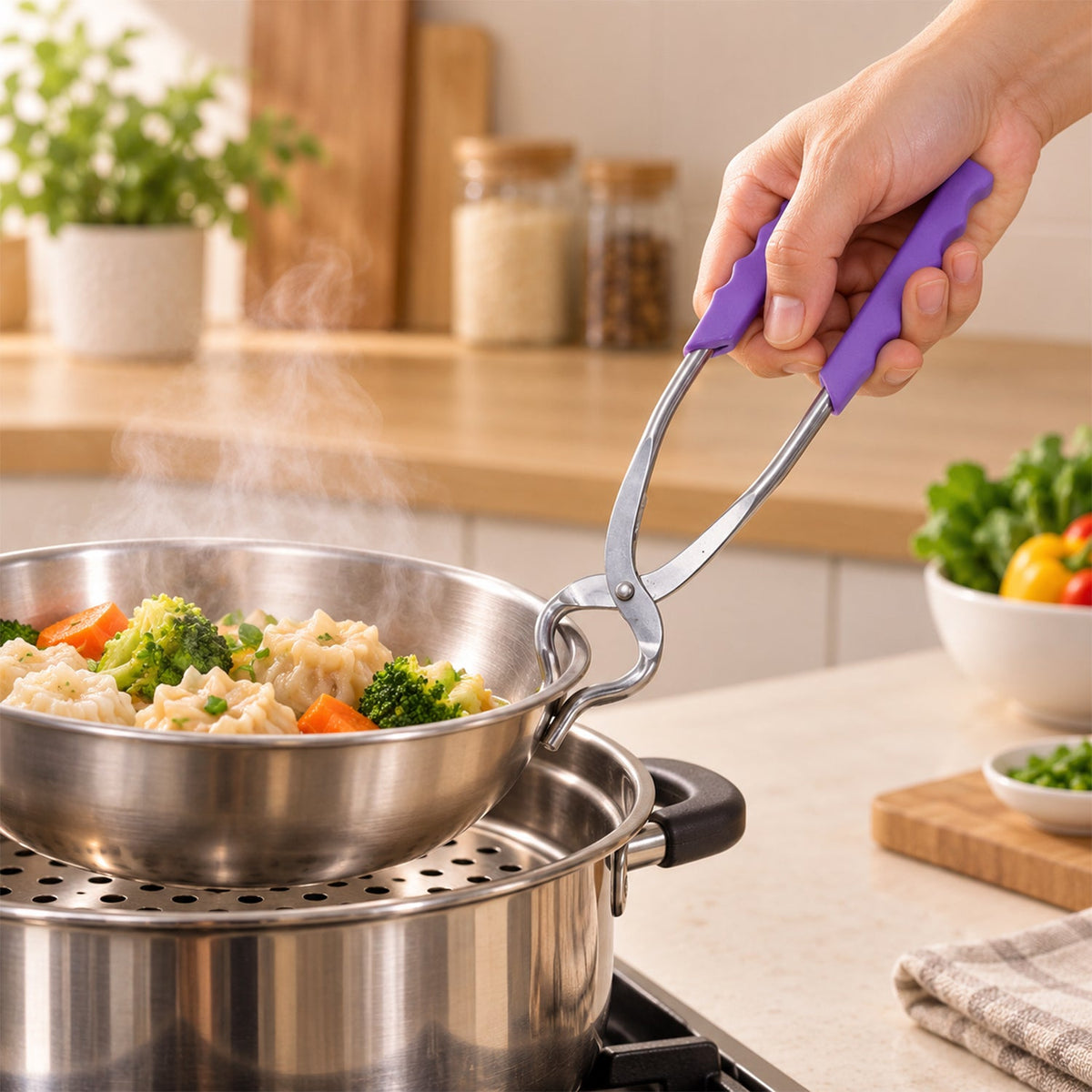 A hand holding a stainless steel pot lifter with purple handles, lifting a bowl of vegetables from a steamer.