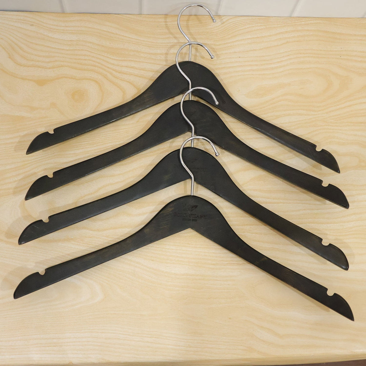Assortment of clothing hanging on premium clothes hangers in a closet.