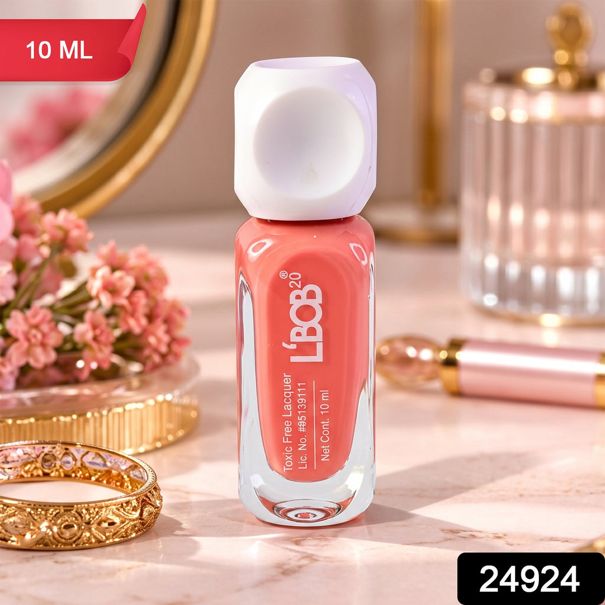 A small bottle of peach coral nail polish with a white dice-shaped cap sits on a marble surface next to a gold ring â€“ view 2