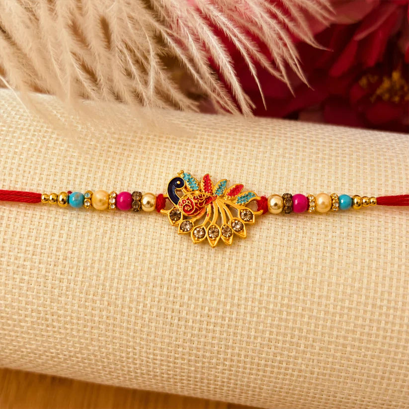 Peacock Rakhi with vibrant stones and red thread, symbolizing sibling love