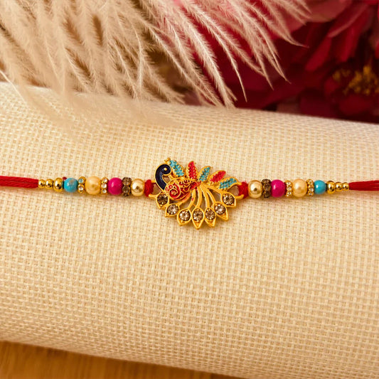 Peacock Rakhi with vibrant stones and red thread, symbolizing sibling love