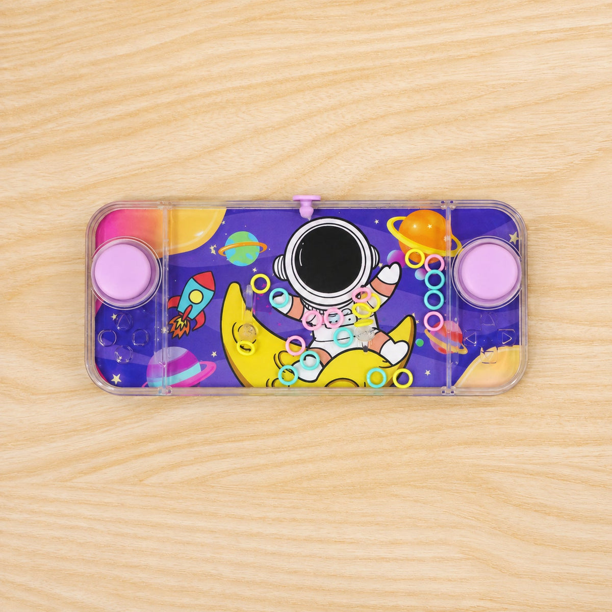 The purple water game with astronaut and planet graphics lies flat on a light brown wooden surface.