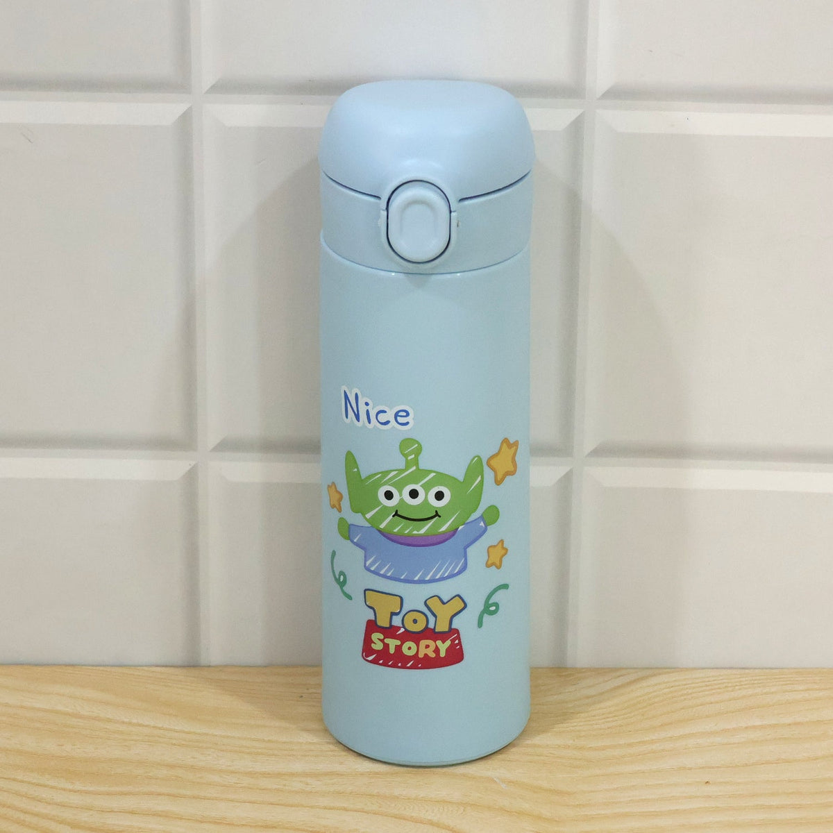 Cartoon print glass water bottle being used on a desk