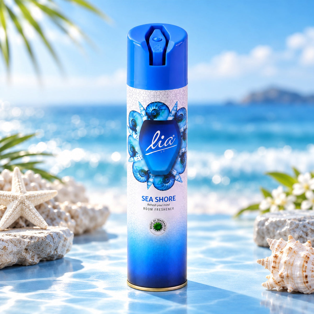 A blue and white aerosol spray can with a seashell design stands on a reflective surface by the ocean.