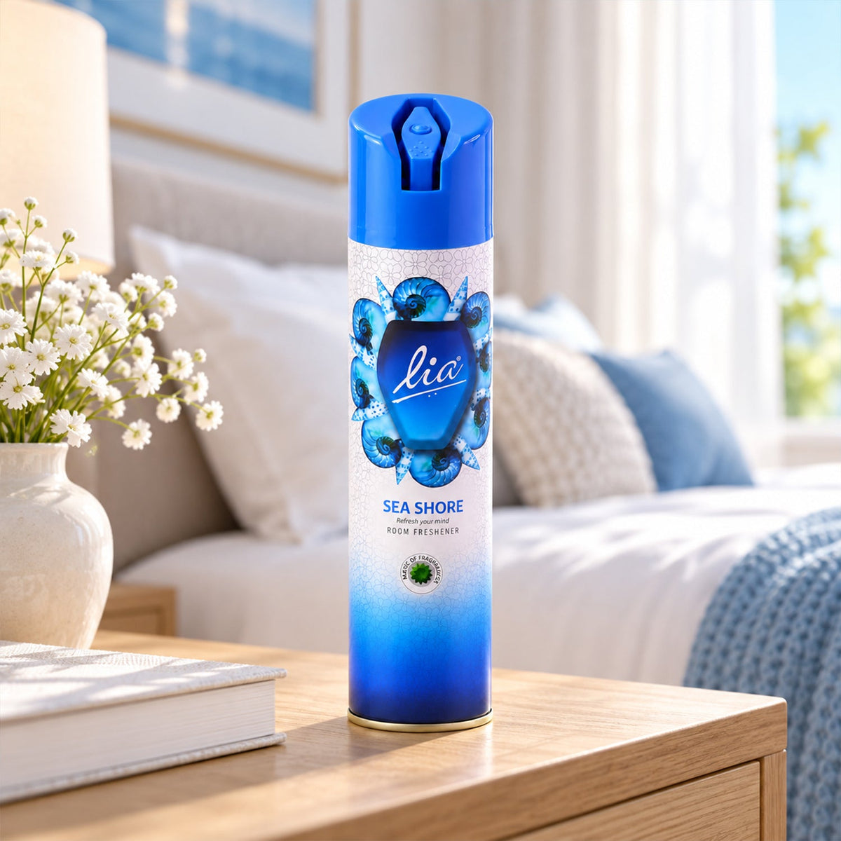 A blue and white aerosol spray can with a seashell design sits on a wooden nightstand in a bedroom.