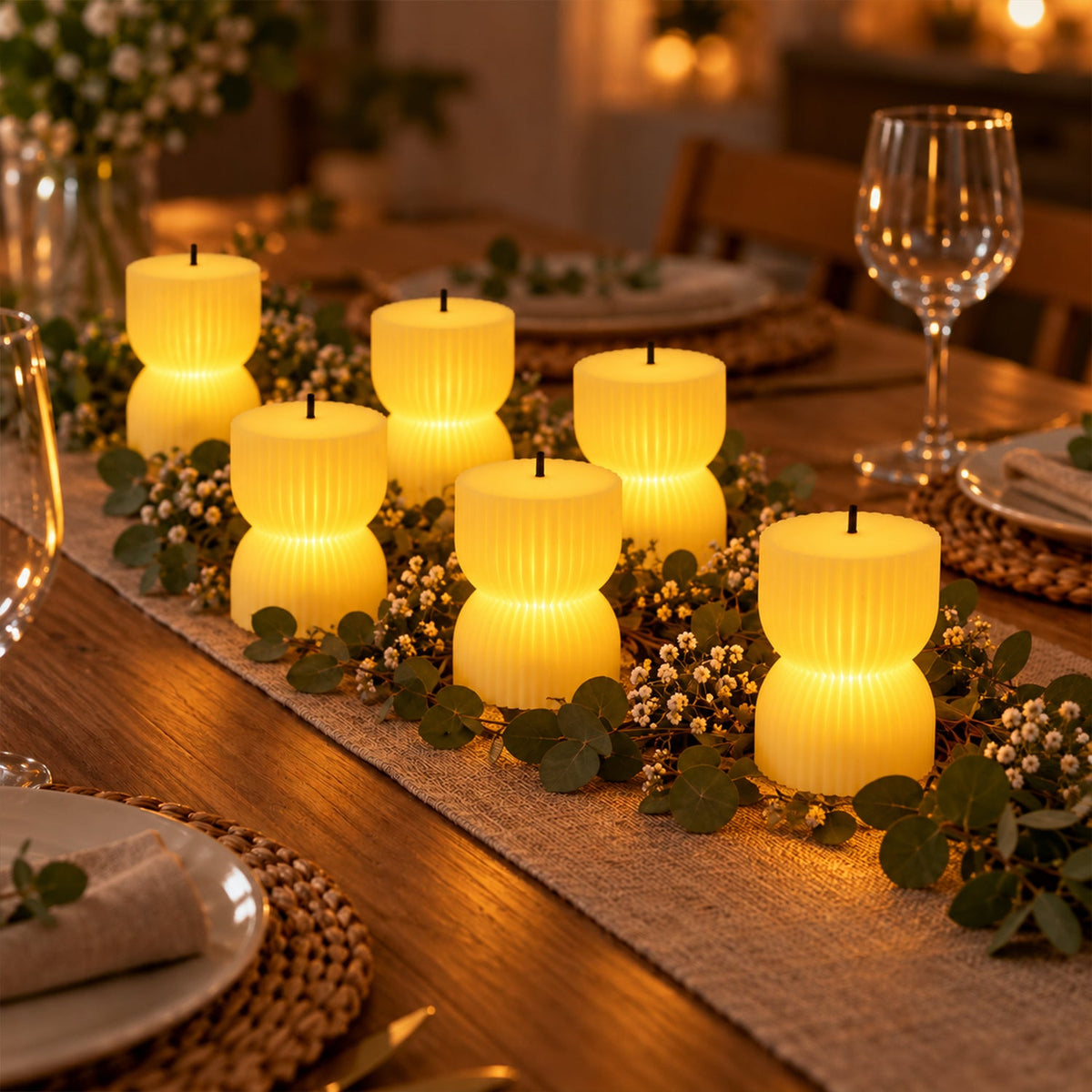 Six glowing ribbed LED candles arranged along a table runner with green foliage and white berries on a dining table.