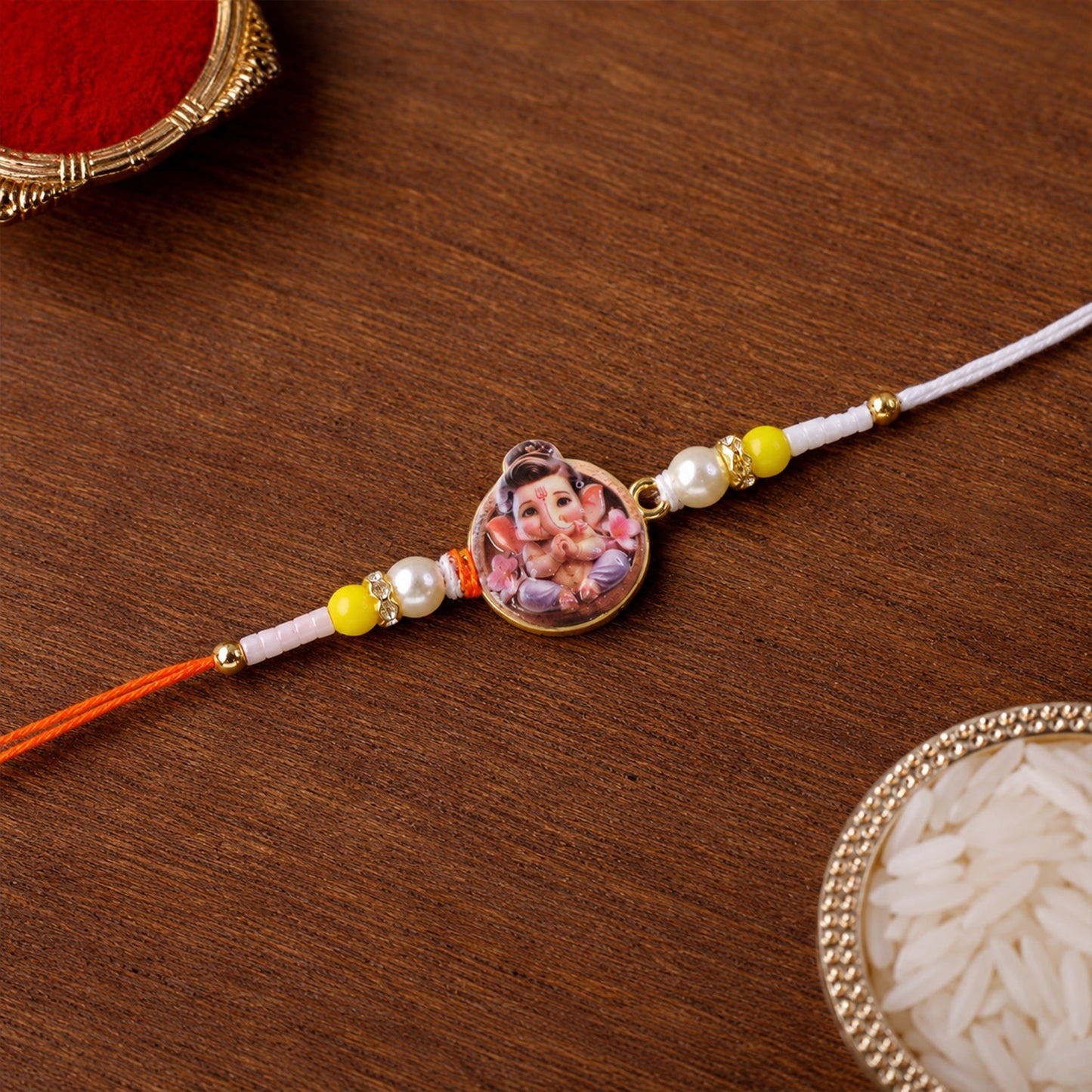 Close-up of Ganesh Ji designer Rakhi with yellow beads and vibrant design
