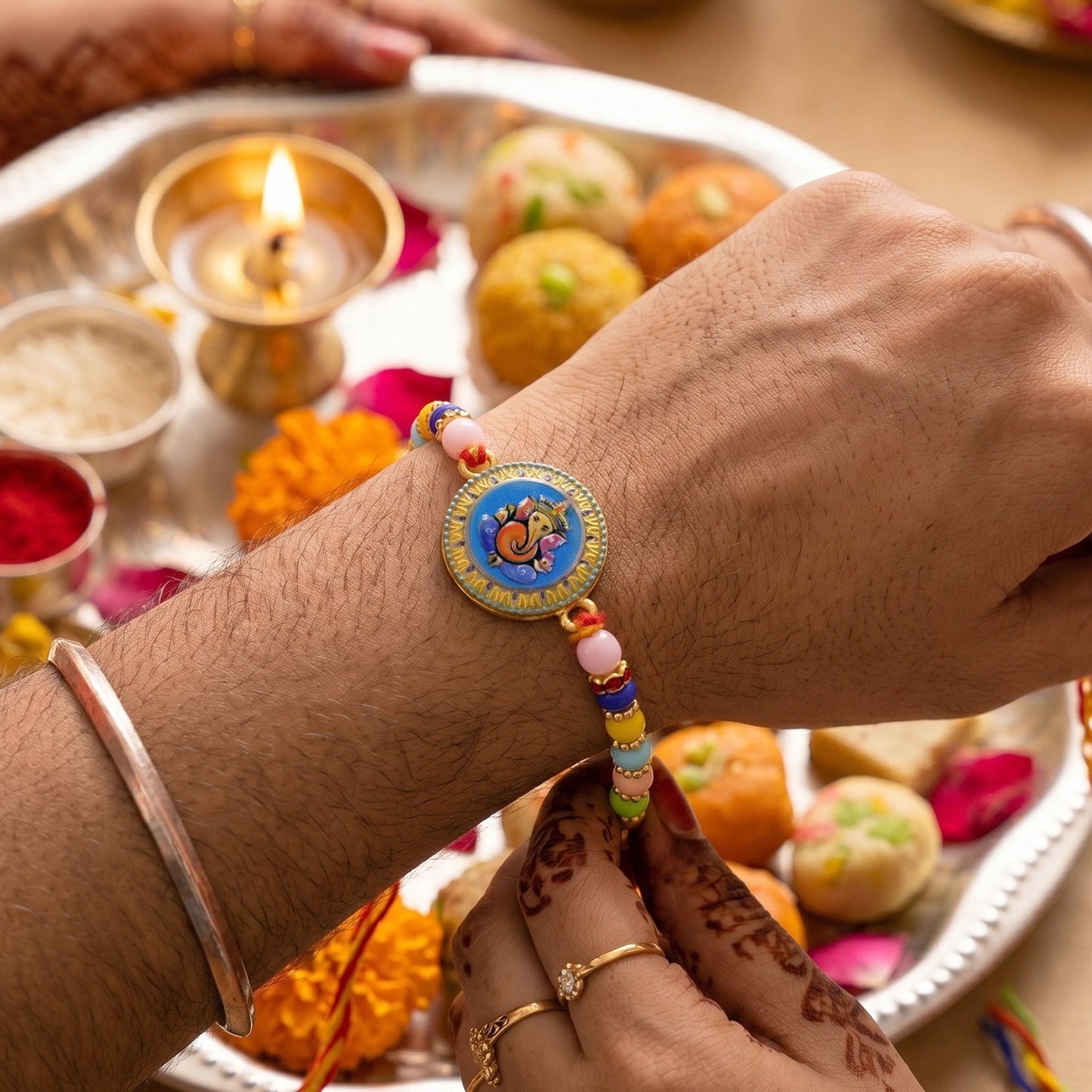 Close-up of Lord Ganesha coin on designer Rakhi